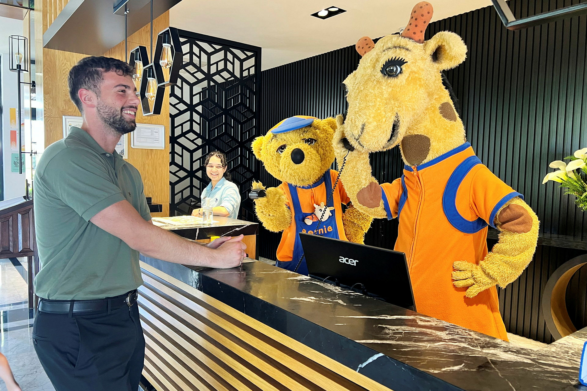 Två personer utklädda till en giraff och en björn står vid receptionen. (AI-genererad text)