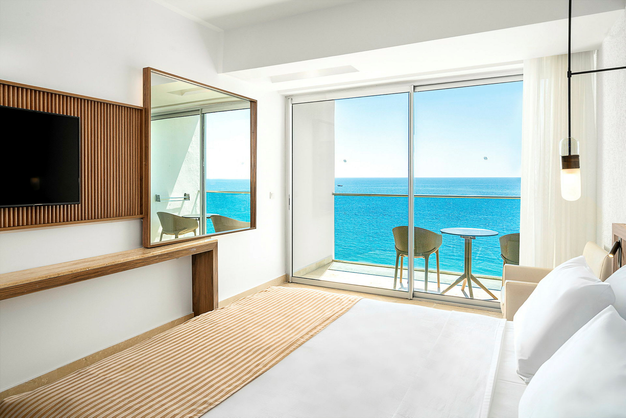 Hotellrum med utsikt mot havet från balkong. (AI-genererad text)