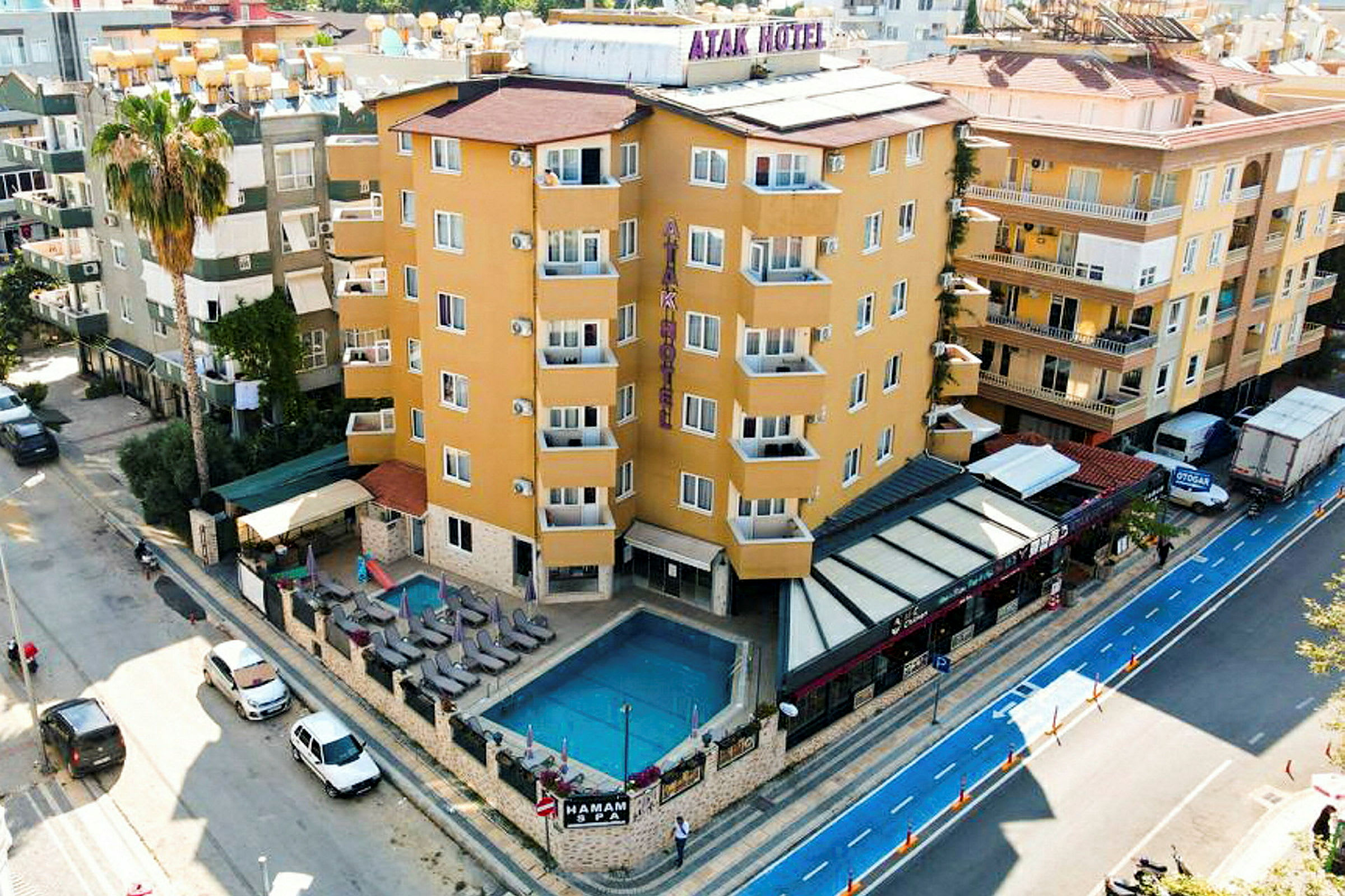 Ett hotell vid en väg med en utomhuspool, solstolar och en liten sittgrupp. (AI-genererad text)