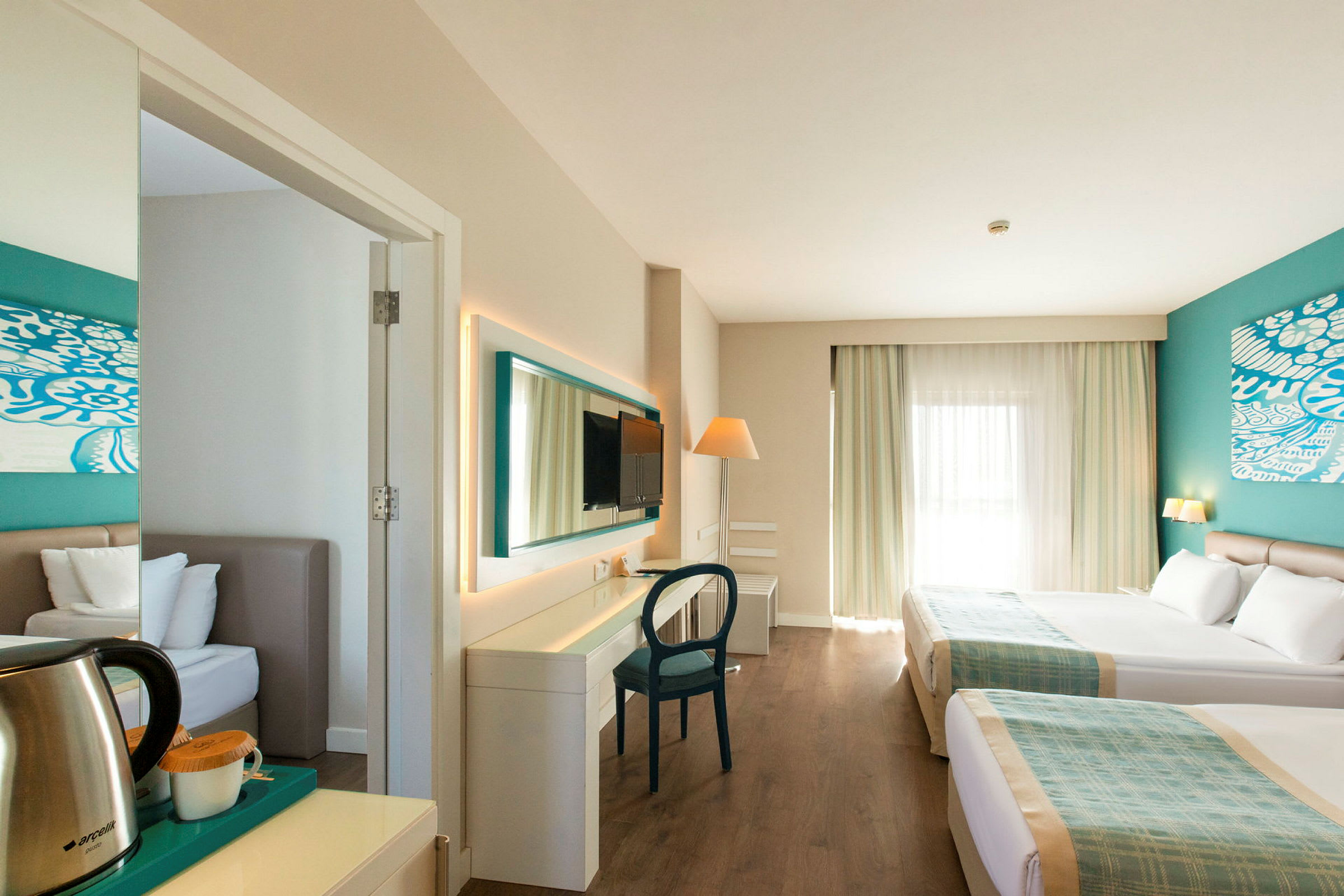 Ett hotellrum med två sängar, skrivbord och sittmöbler. (AI-genererad text)