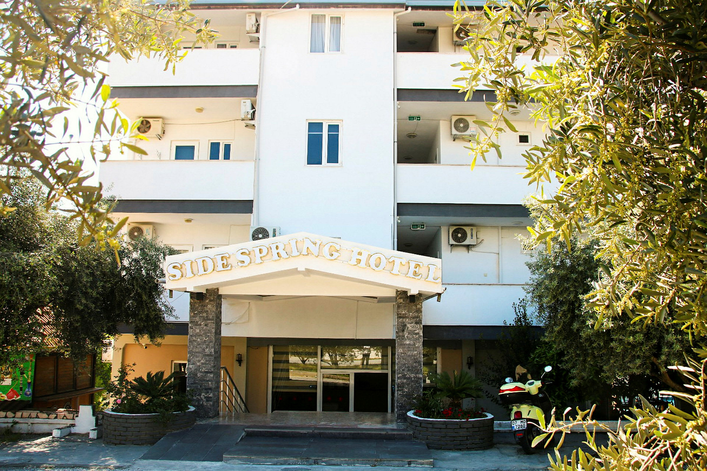 Bild av en hotellbyggnad med en skylt som säger 'Side Spring Hotel'. (AI-genererad text)