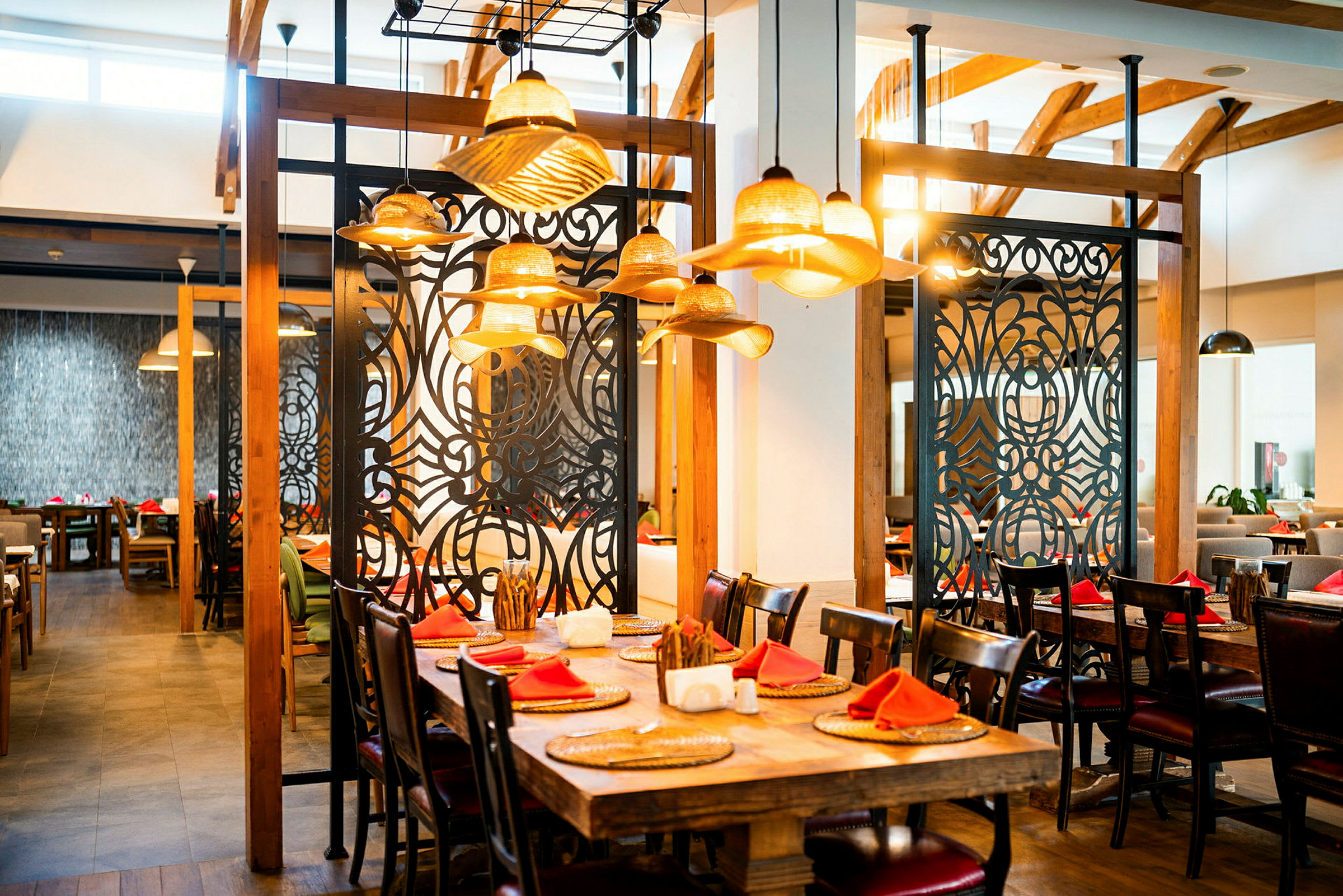 En restaurang med träinredning, dekorerade svartvita avdelare och dukade bord med röda servetter. (AI-genererad text)