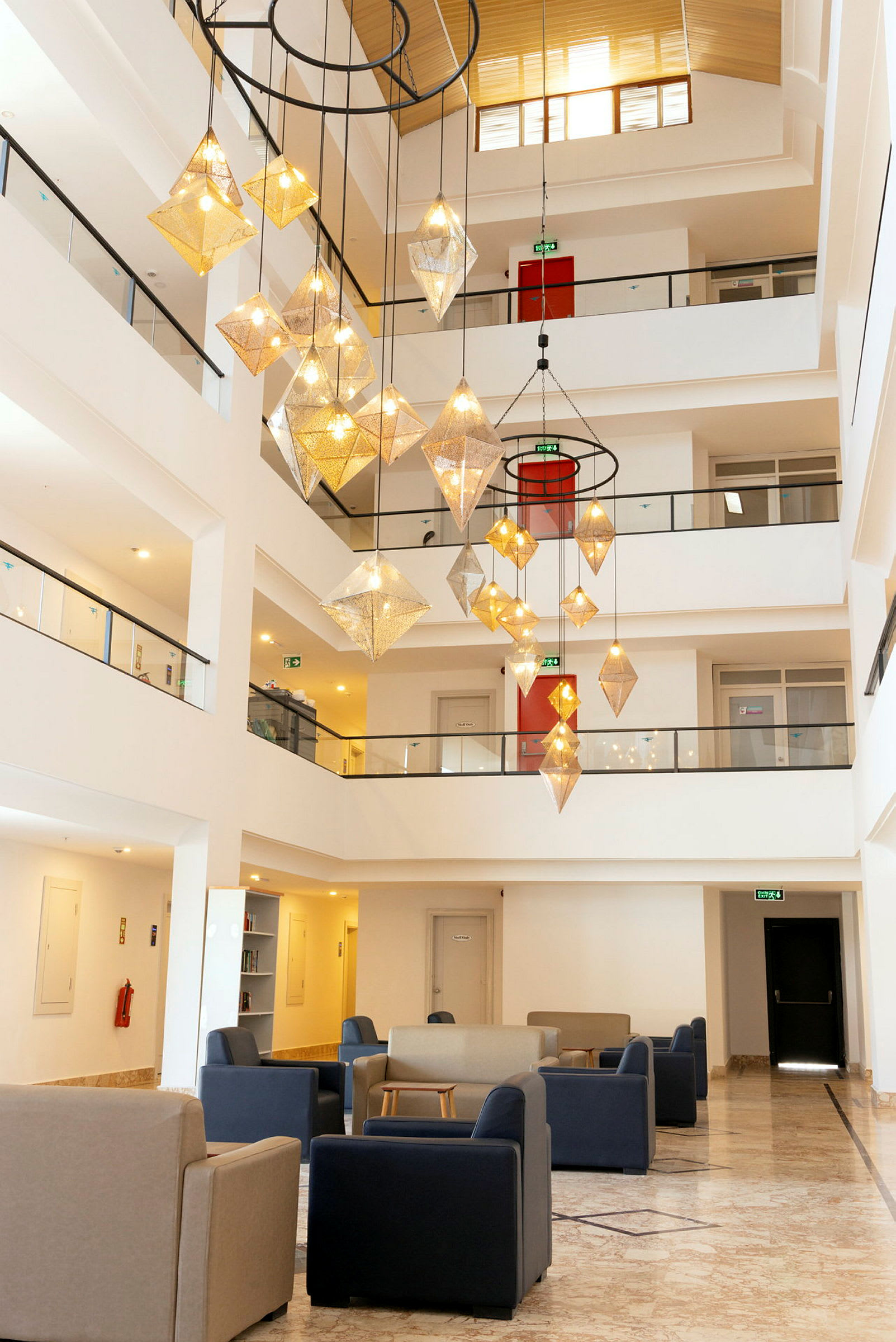 Interiör av ett hotell med sittplatser och en stor ljuskrona. (AI-genererad text)