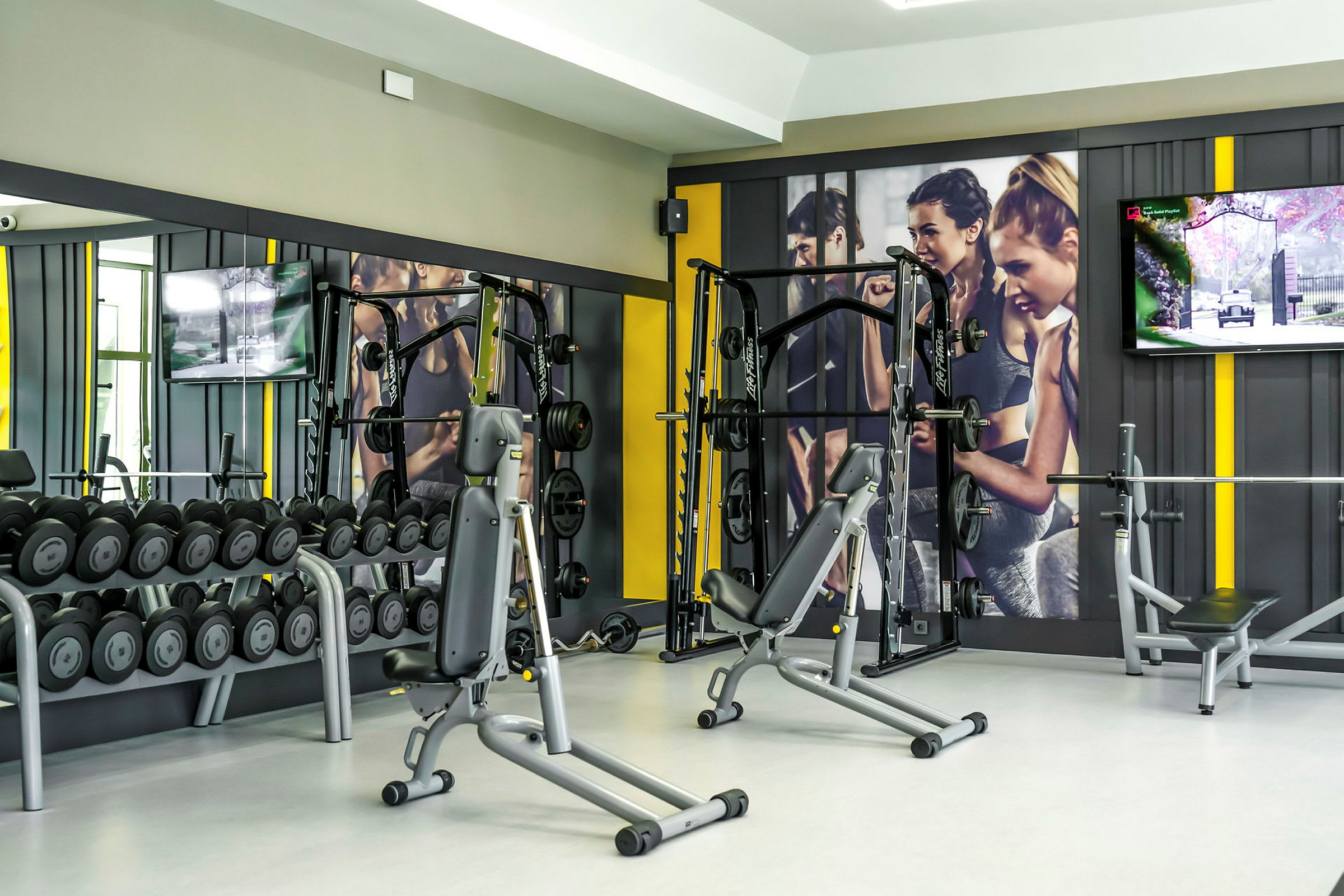 Ett välutrustat gym med träningsmaskiner och hantlar. (AI-genererad text)