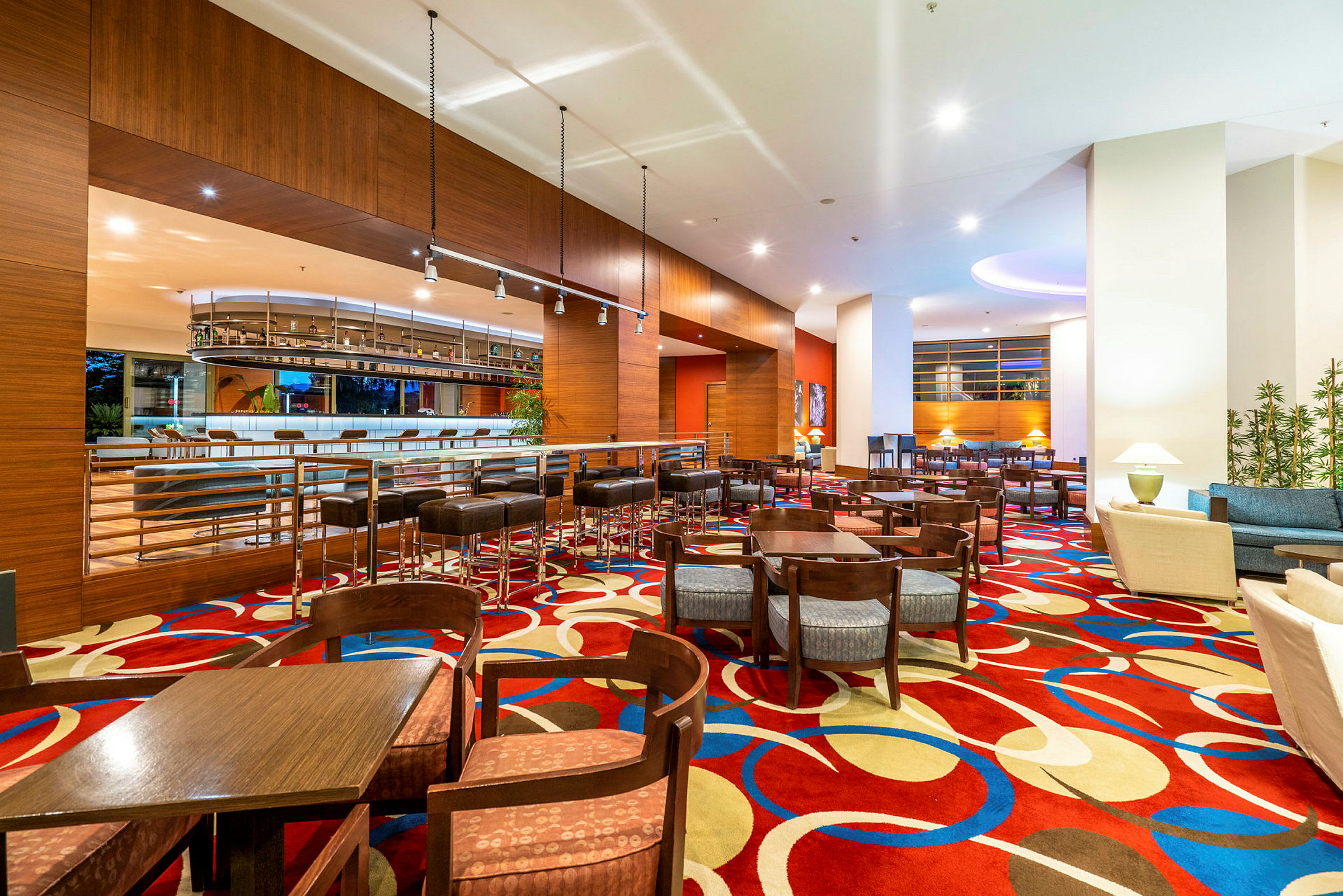 Hotellobby med färgglad matta och sittgrupper. (AI-genererad text)