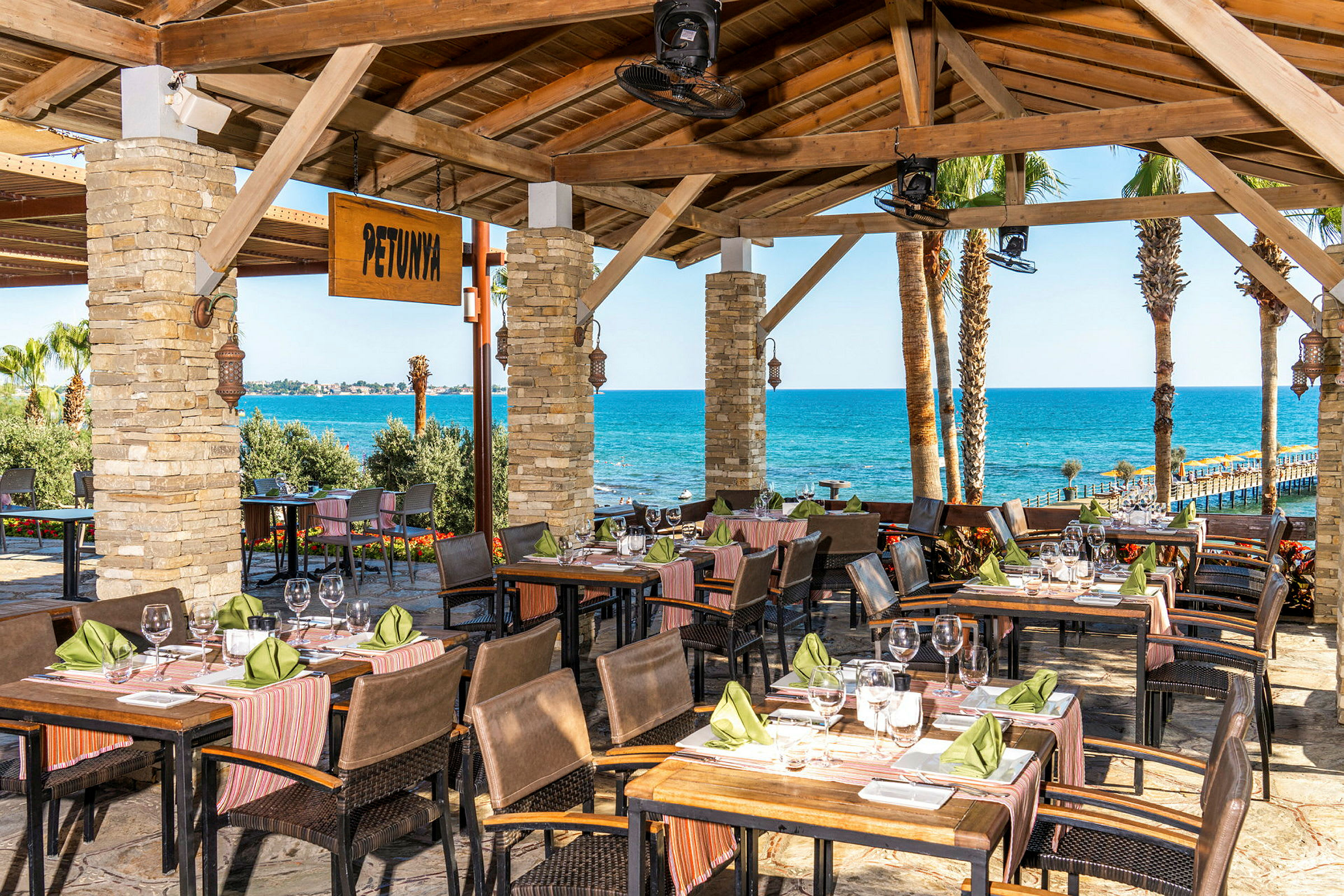 En restaurang med utsikt över havet och palmträd. (AI-genererad text)