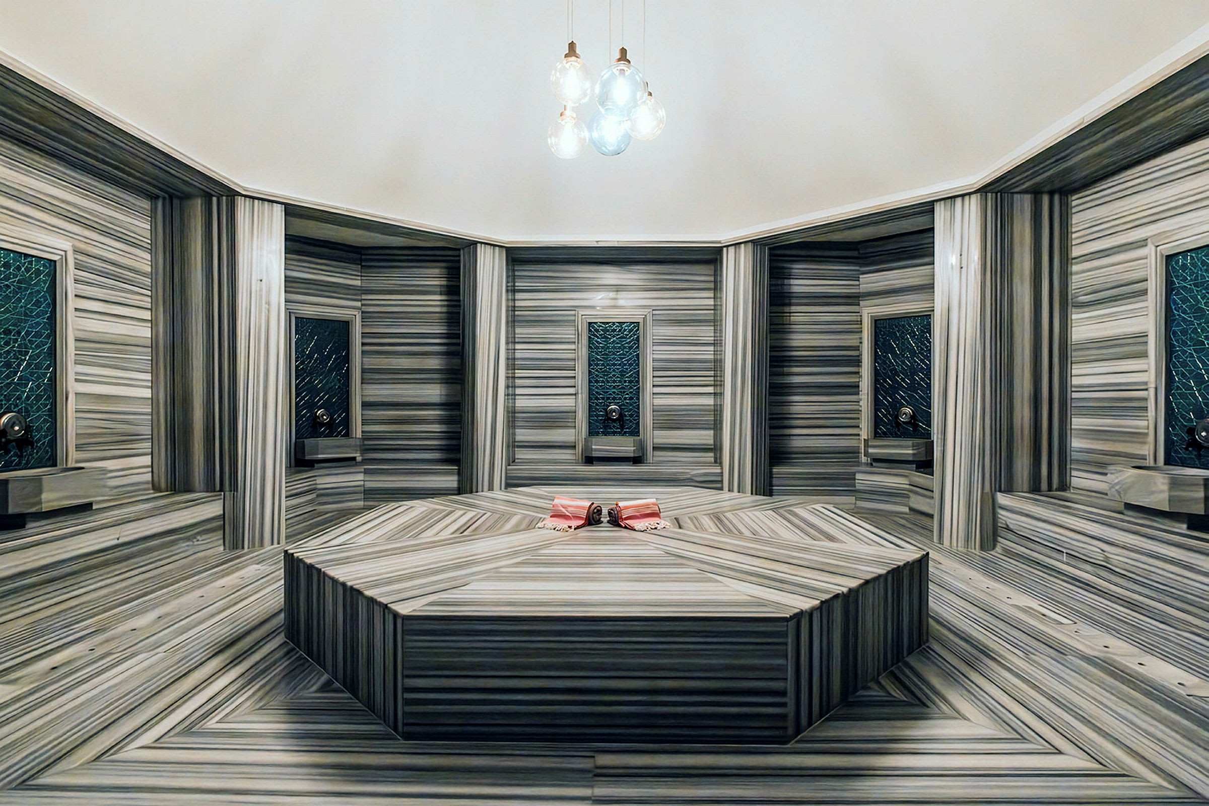 Interiör av ett turkiskt hamam med marmorväggar och ett centralt stenblock. (AI-genererad text)