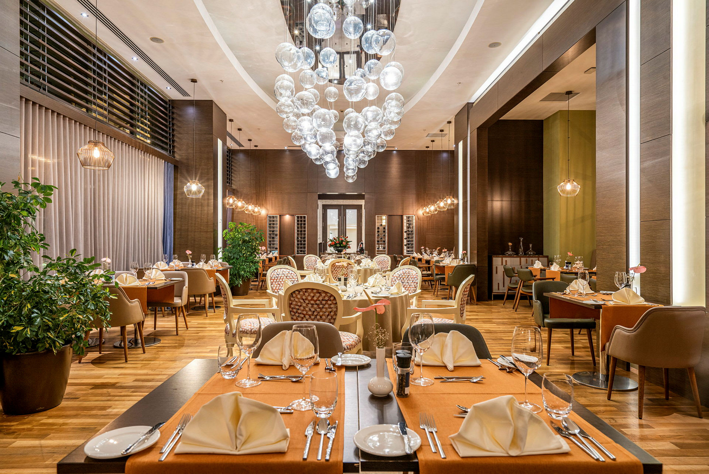 En elegant restaurang med dukade bord, stolar och en dekorativ ljuskrona. (AI-genererad text)