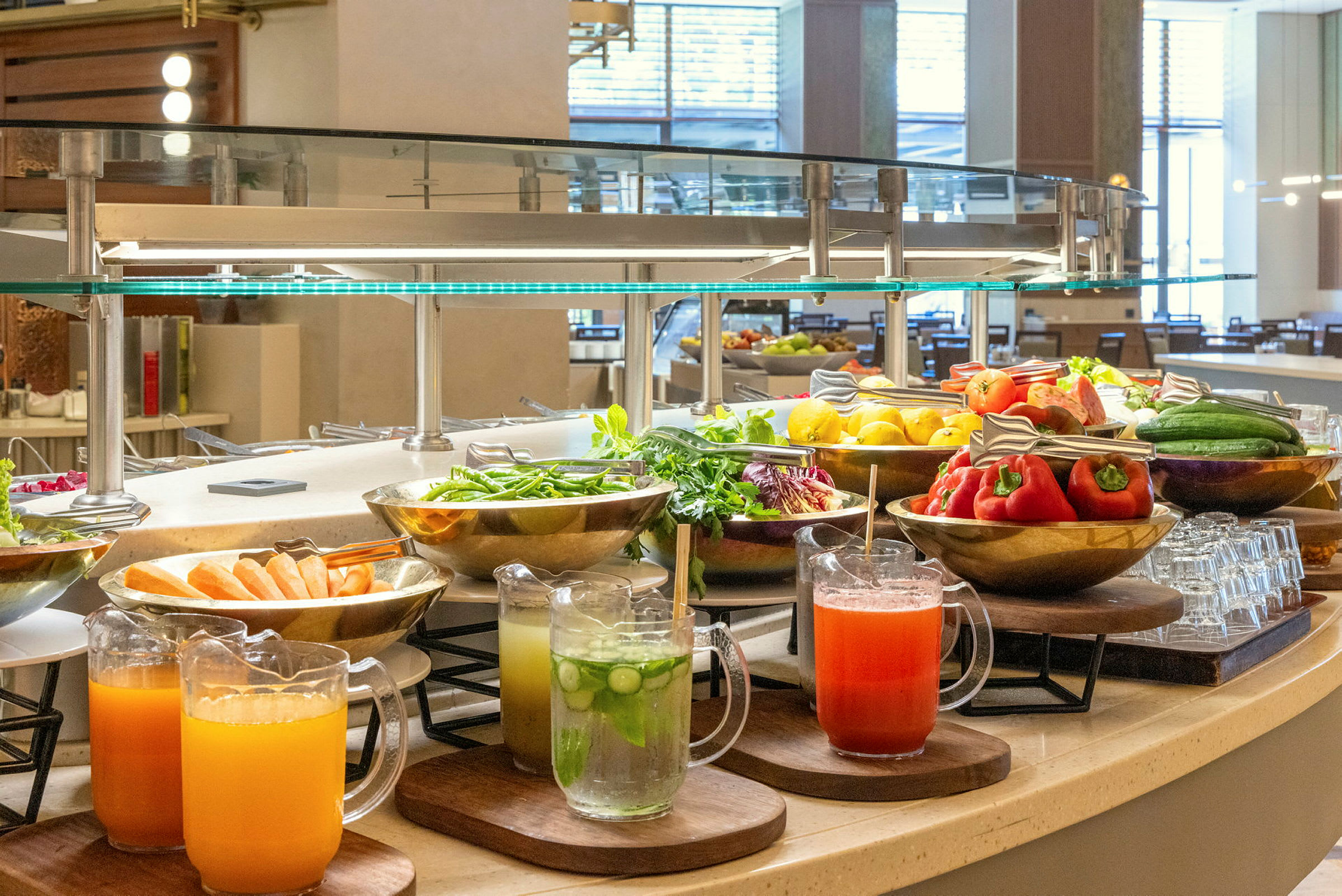 En buffé med olika grönsaker, färska frukter och juicer på ett serveringsbord. (AI-genererad text)