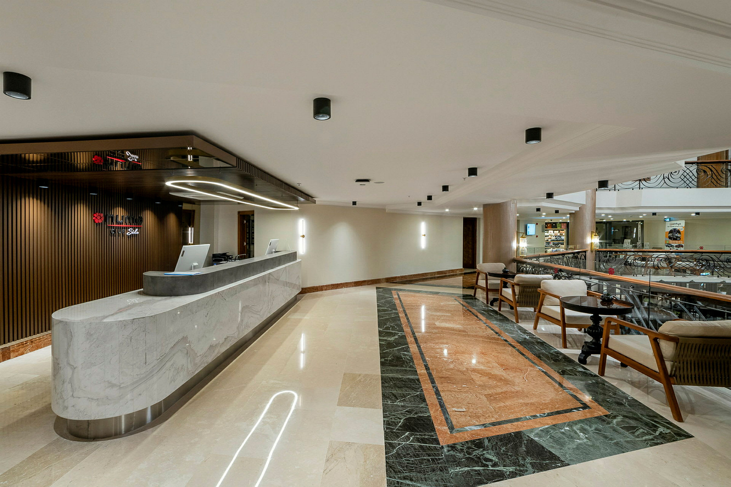 Hotellets lobby med reception och sittgrupp. (AI-genererad text)