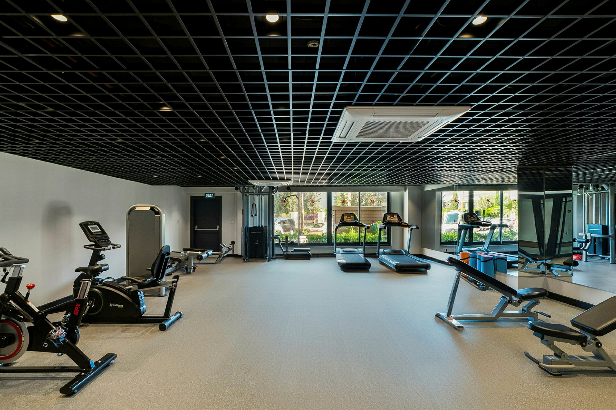 Ett gym med träningsutrustning såsom löpband, träningscyklar och styrketräningsmaskiner. (AI-genererad text)
