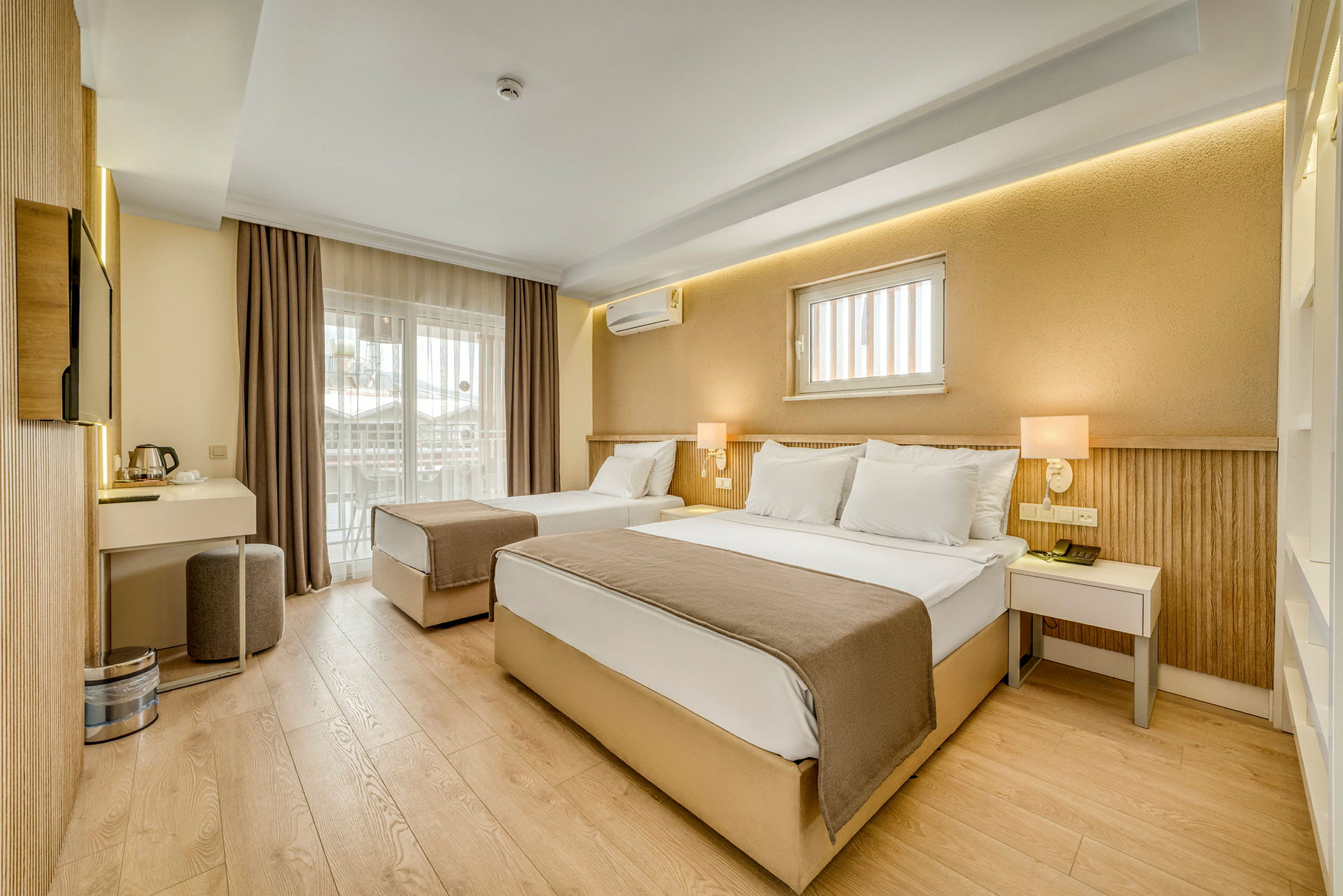 Ett hotellrum med två sängar, modern inredning och en balkong. (AI-genererad text)