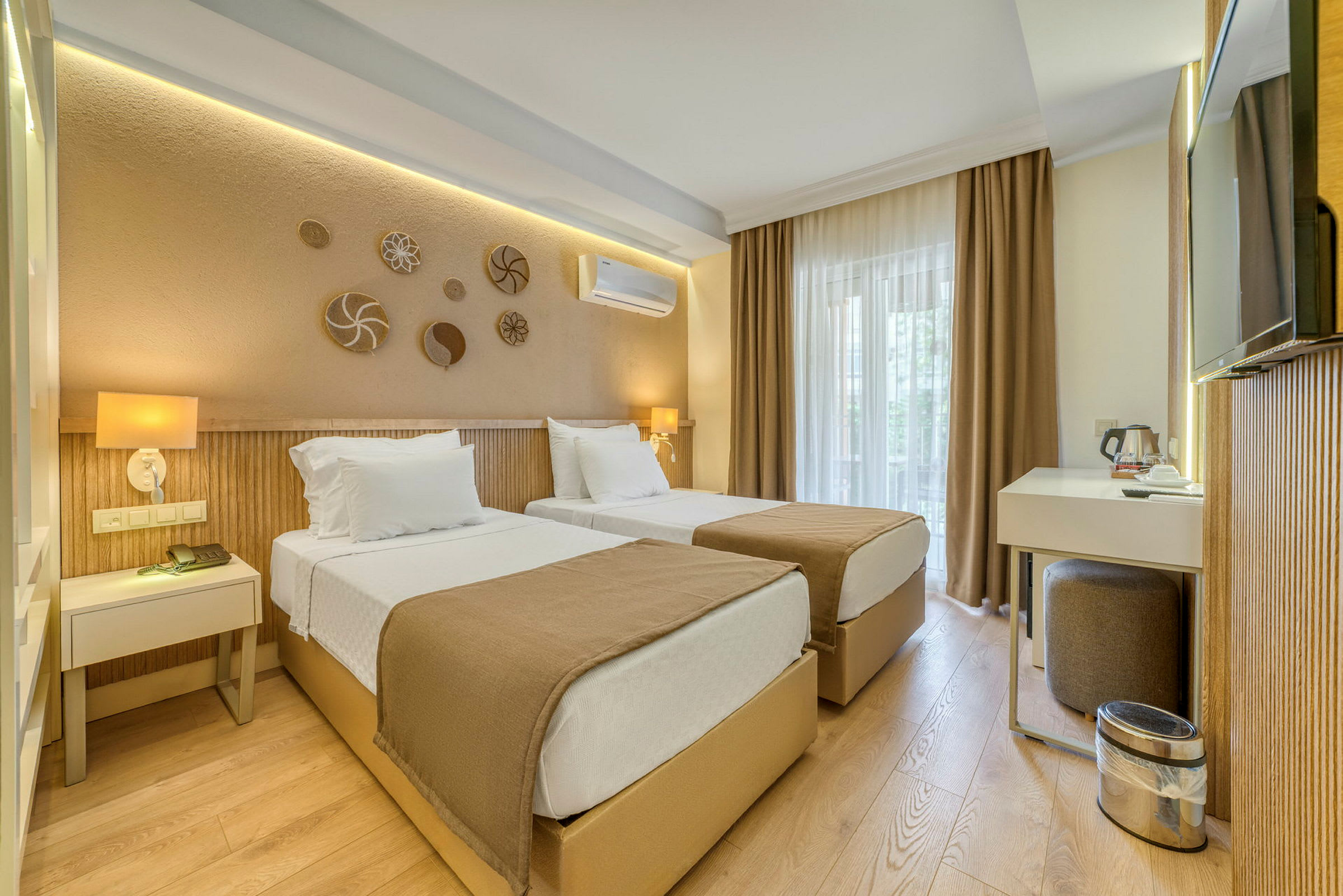 Ett hotellrum med två enkelsängar, en skrivbordshörna och neutrala färgtoner. (AI-genererad text)