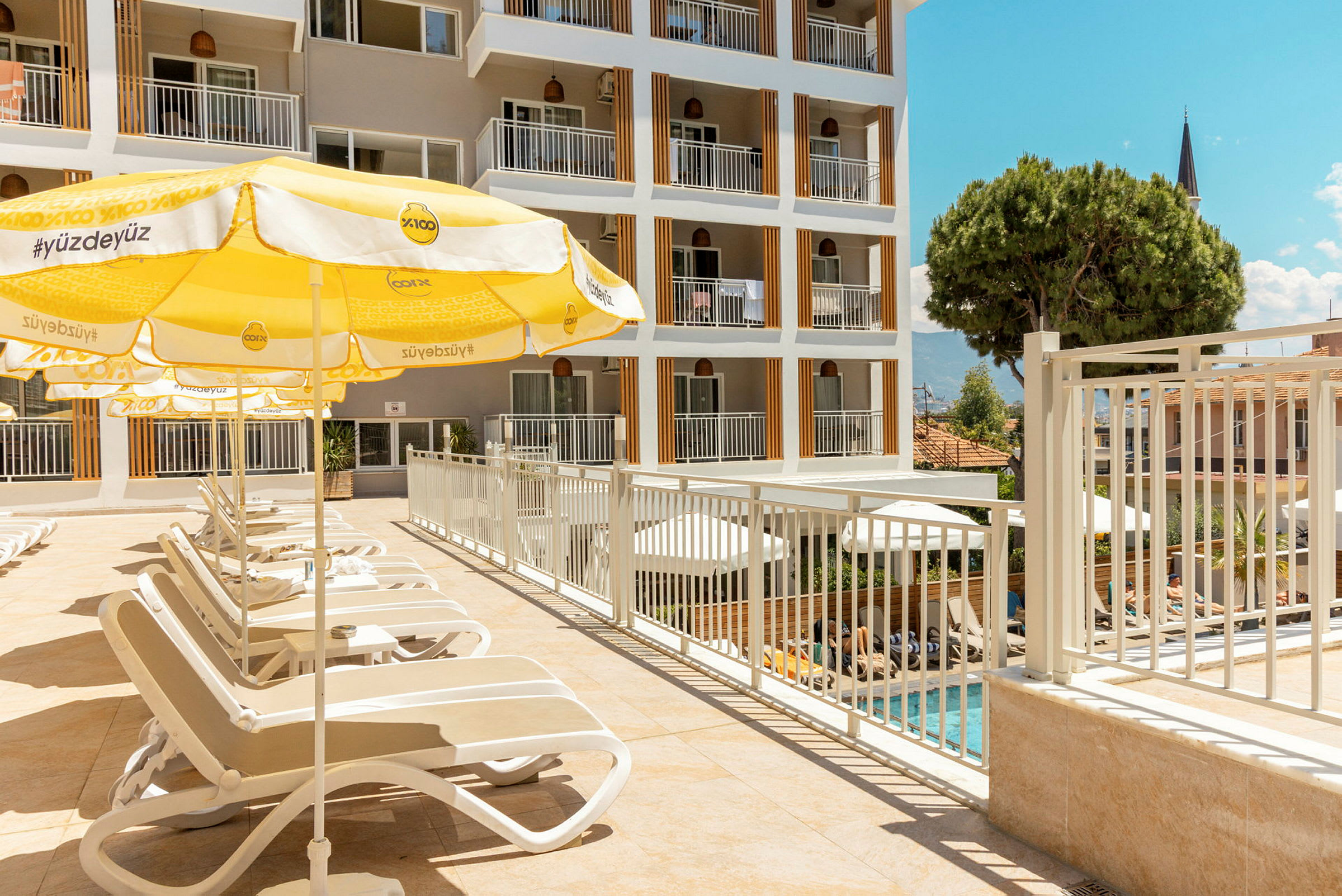 Solstolar placerade vid en utomhuspool bredvid ett hotell. (AI-genererad text)