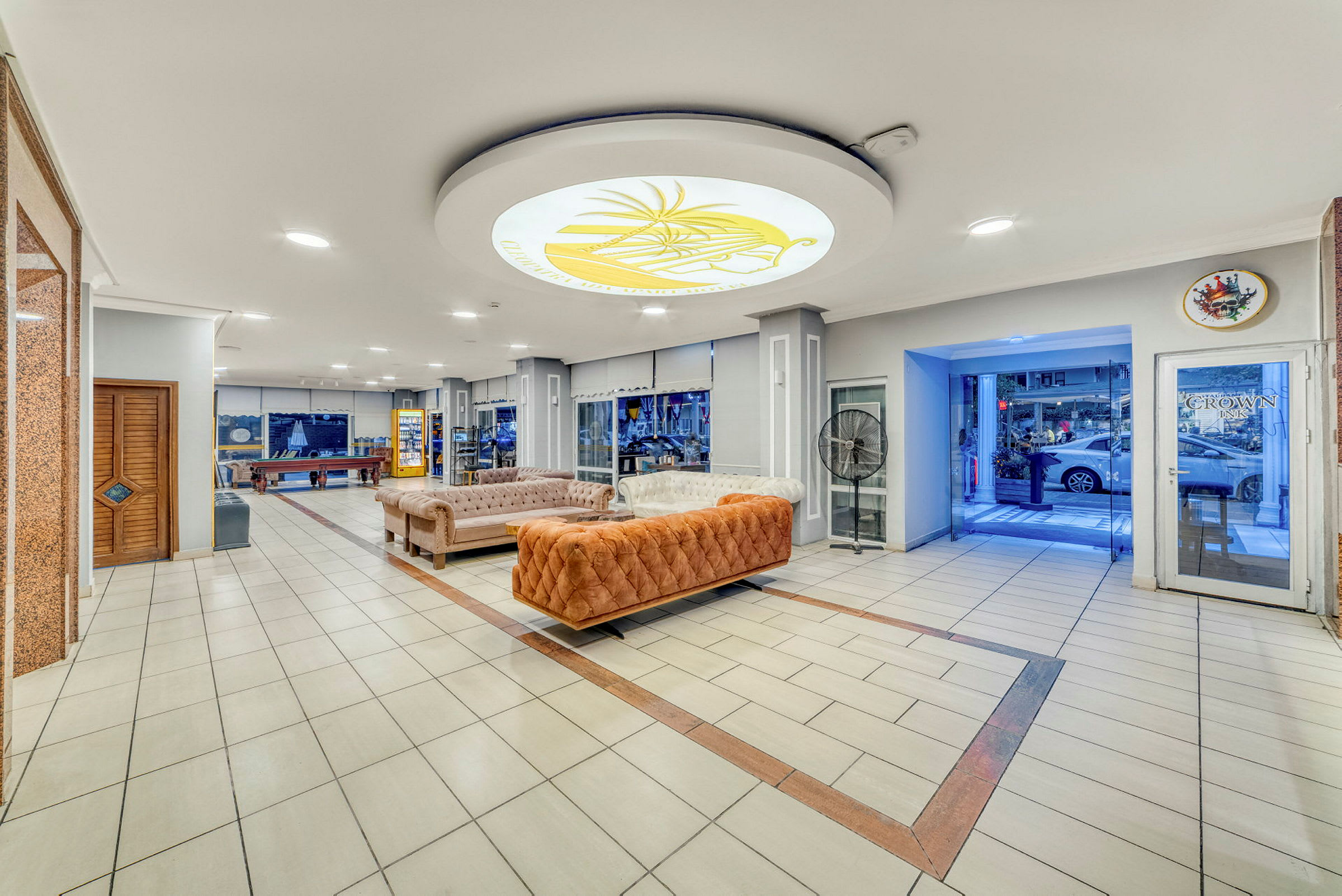 Hotellobby med soffor, bordspel och en glasentré. (AI-genererad text)