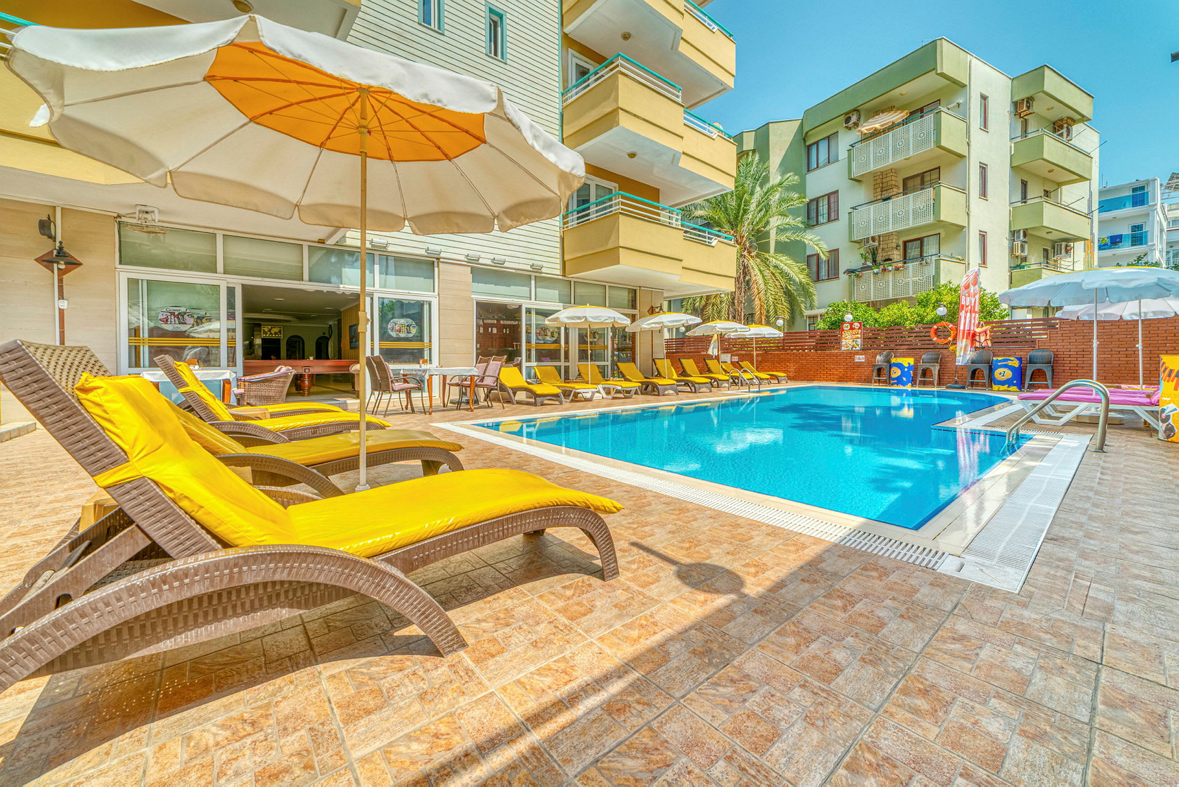 Utomhuspool med solstolar och parasoll vid ett hotell. (AI-genererad text)