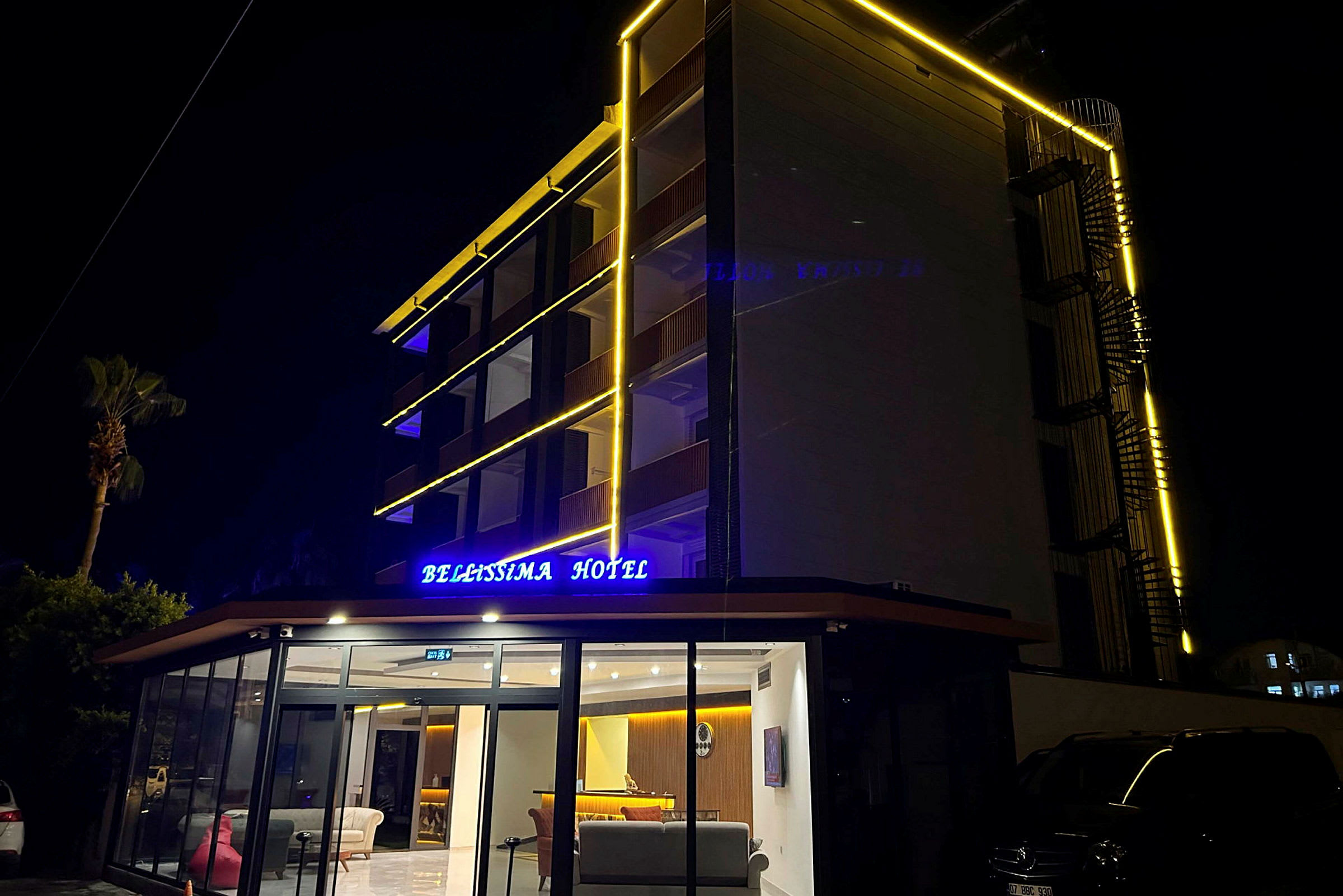 Hotellbyggnad med lysande skylt och fasadbelysning, fotat på natten. (AI-genererad text)