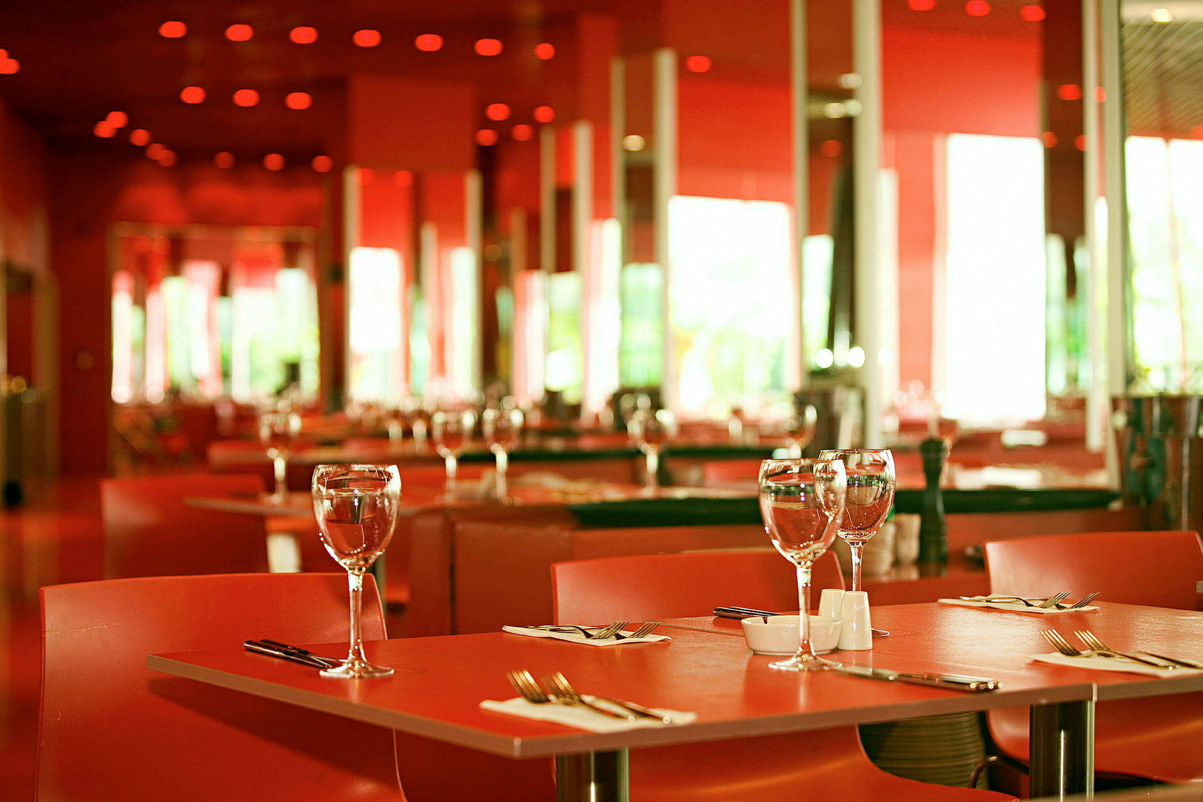 Ett bordsdukade bord i en elegant restaurang med röd inredning. (AI-genererad text)