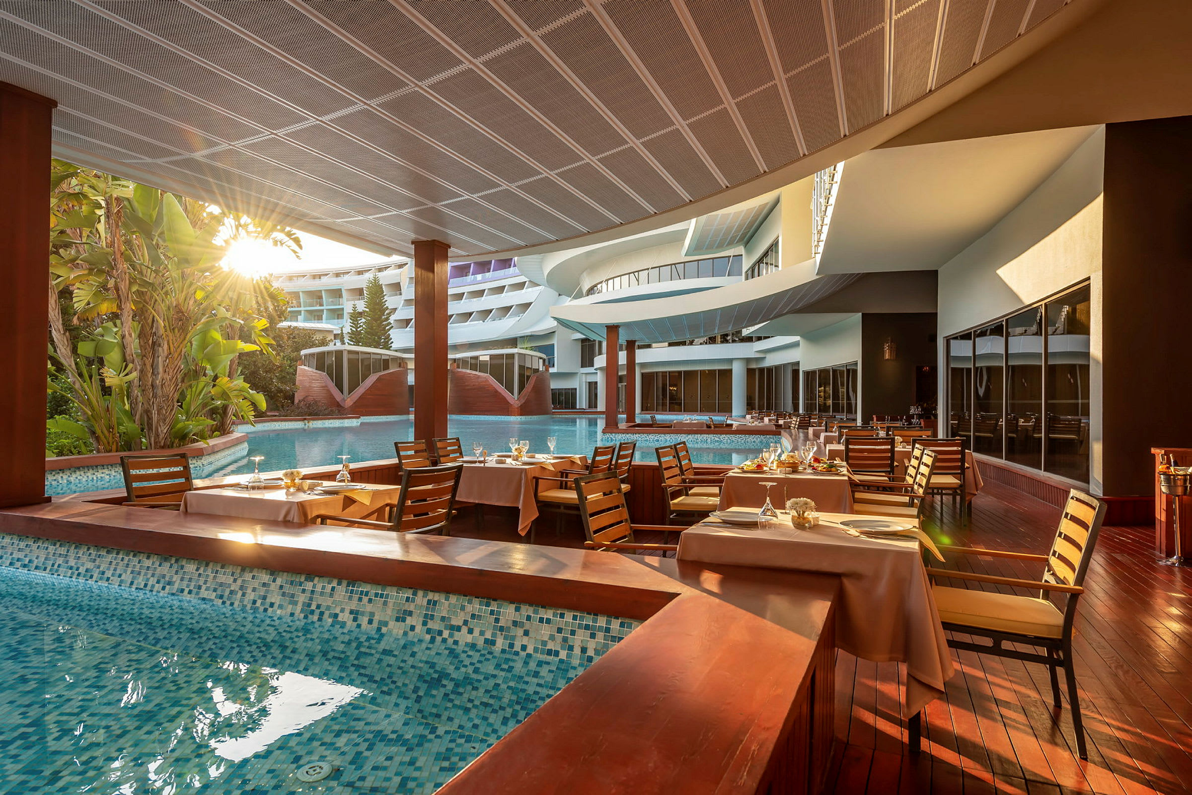 Hotellrestaurang vid en pool med dukade bord. (AI-genererad text)