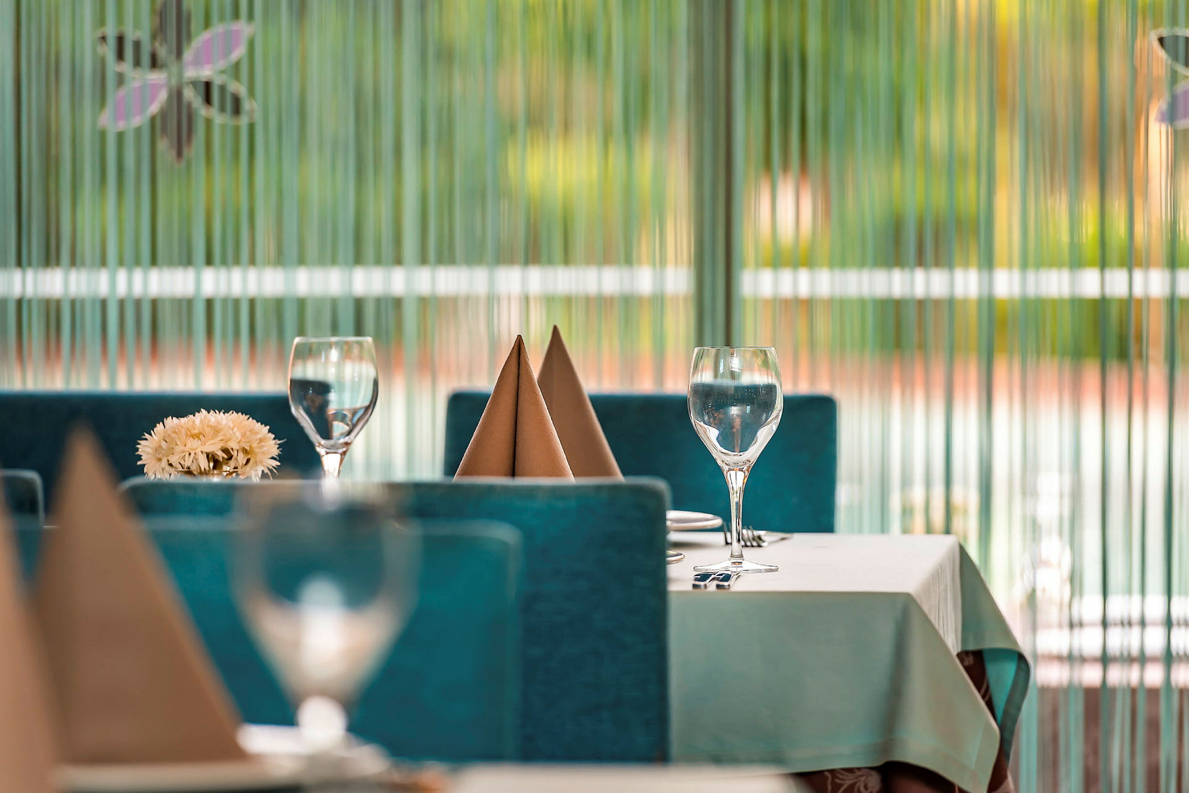 Väl dukat bord med glas och servetter i restaurangmiljö. (AI-genererad text)