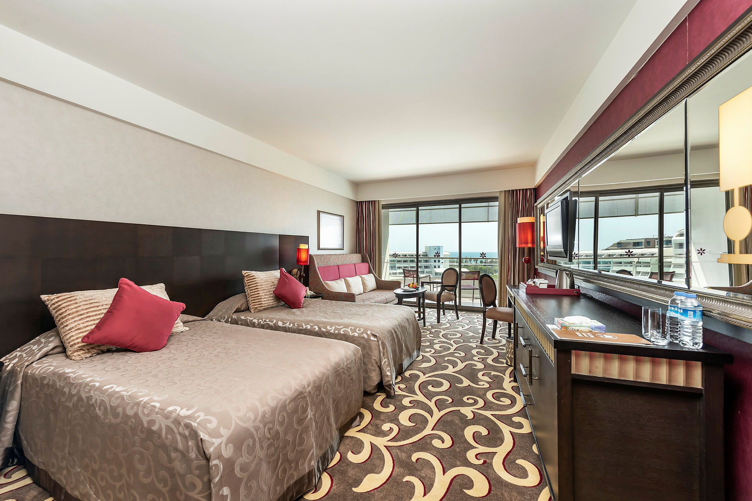 Hotellrum med två sängar, sittgrupp och balkong. (AI-genererad text)