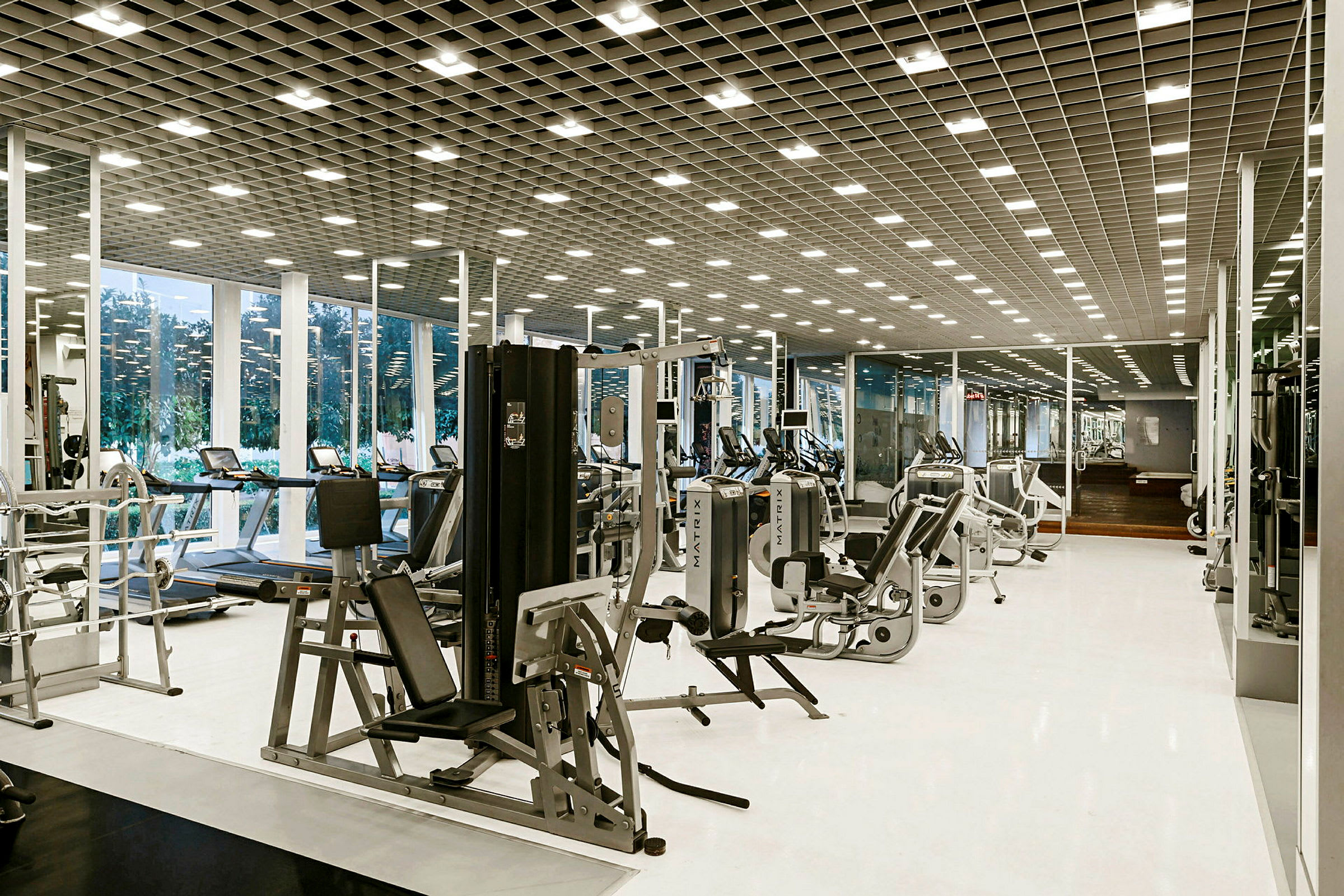 Ett modernt gym med träningsmaskiner och spegelväggar. (AI-genererad text)