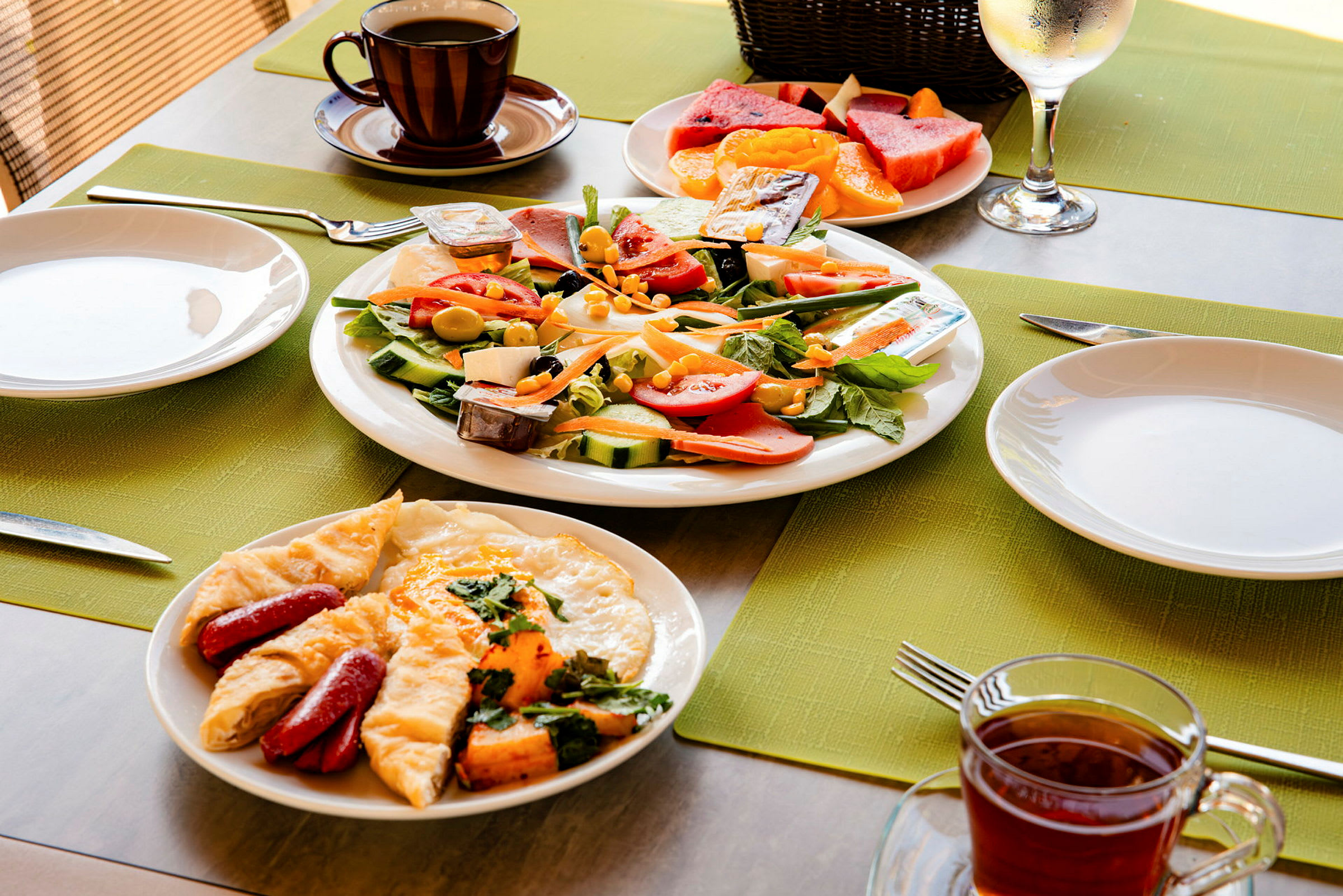 En frukostdukning med sallad, stekt ägg med korv och kaffe. (AI-genererad text)