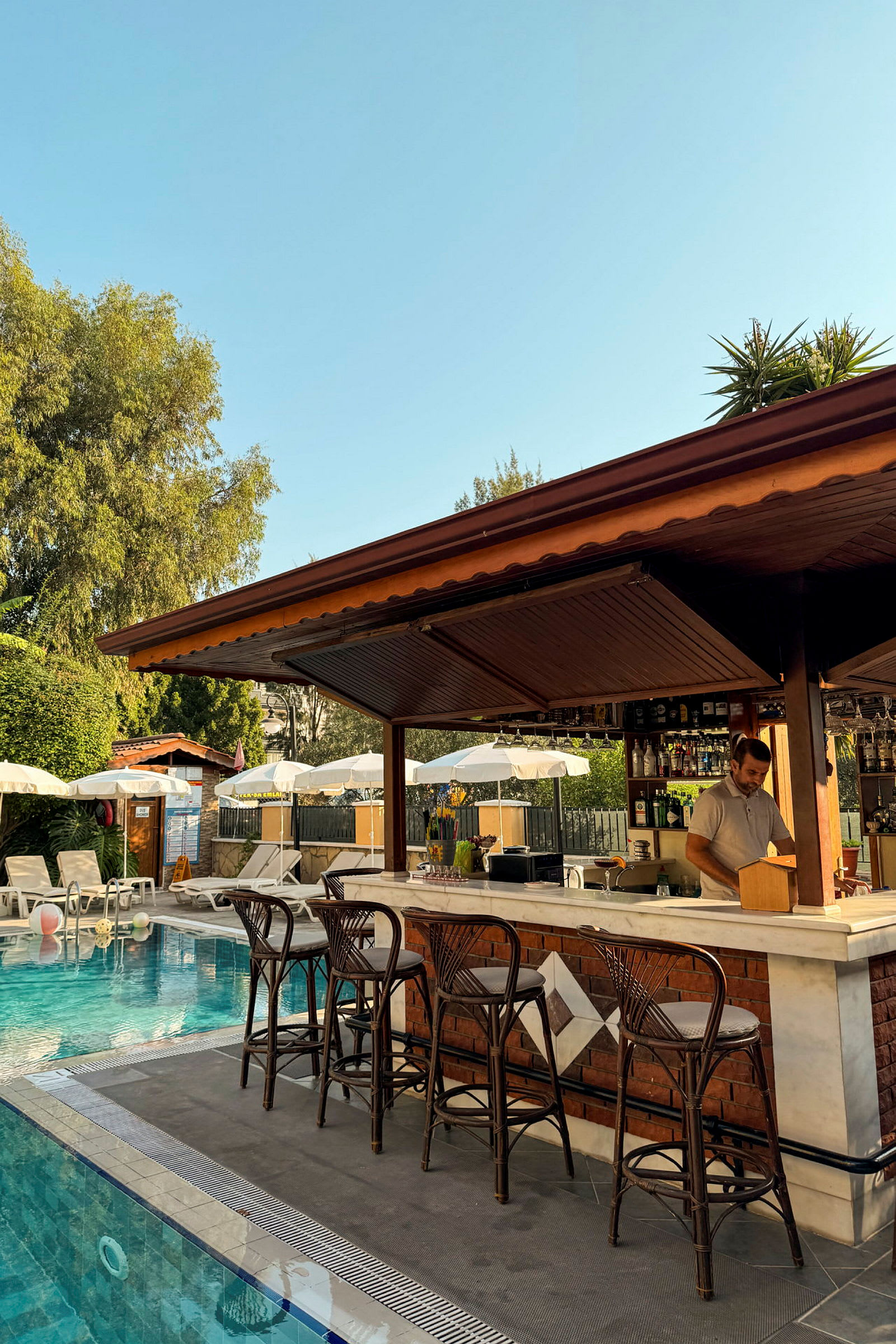 En poolområde med en bar och solparasoller. (AI-genererad text)