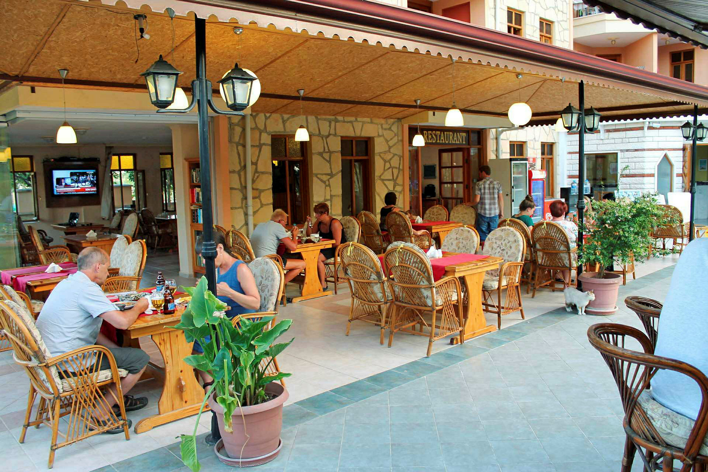 En restaurang med uteservering och möbler i rotting. (AI-genererad text)
