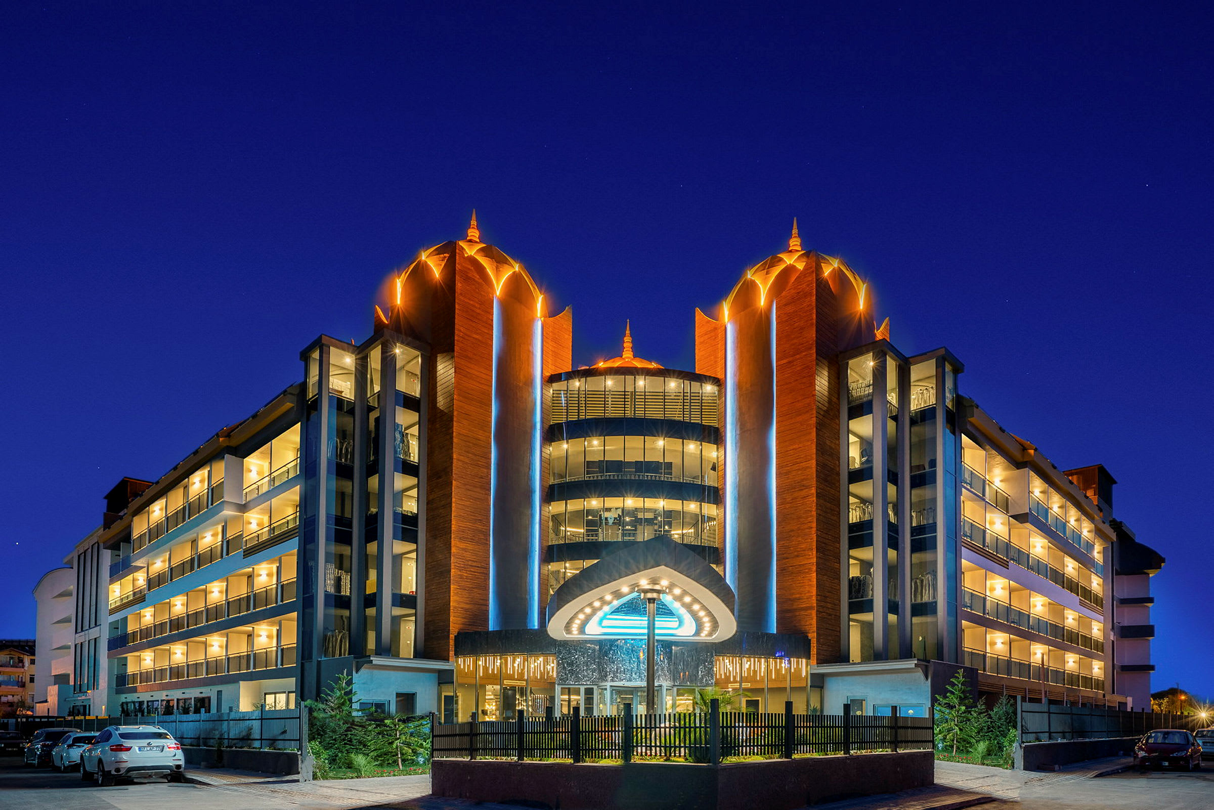 Hotellbyggnad med upplyst fasad och en modern design under natthimlen. (AI-genererad text)