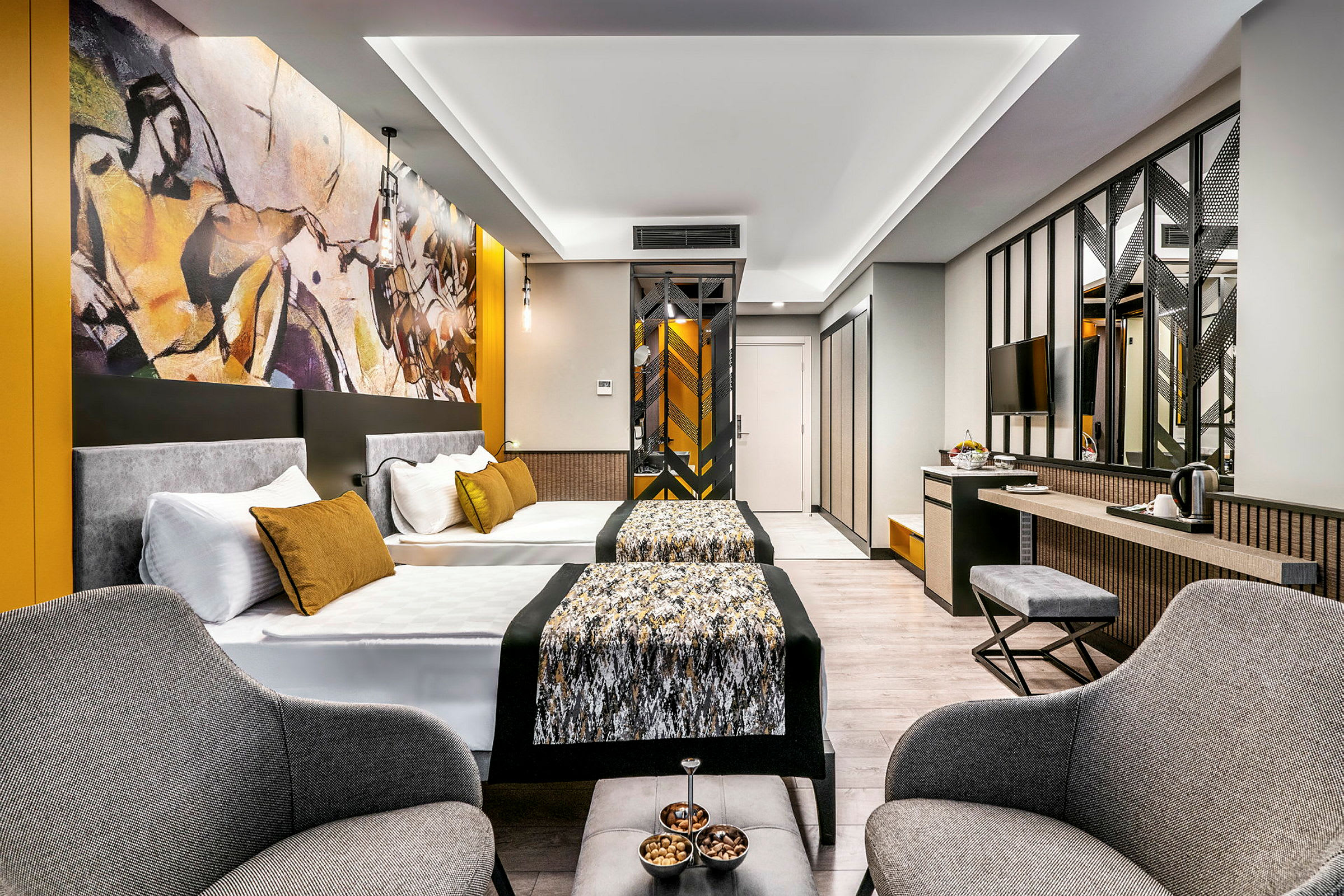 Modernt hotellrum med två sängar, sittgrupp och konst på väggen. (AI-genererad text)