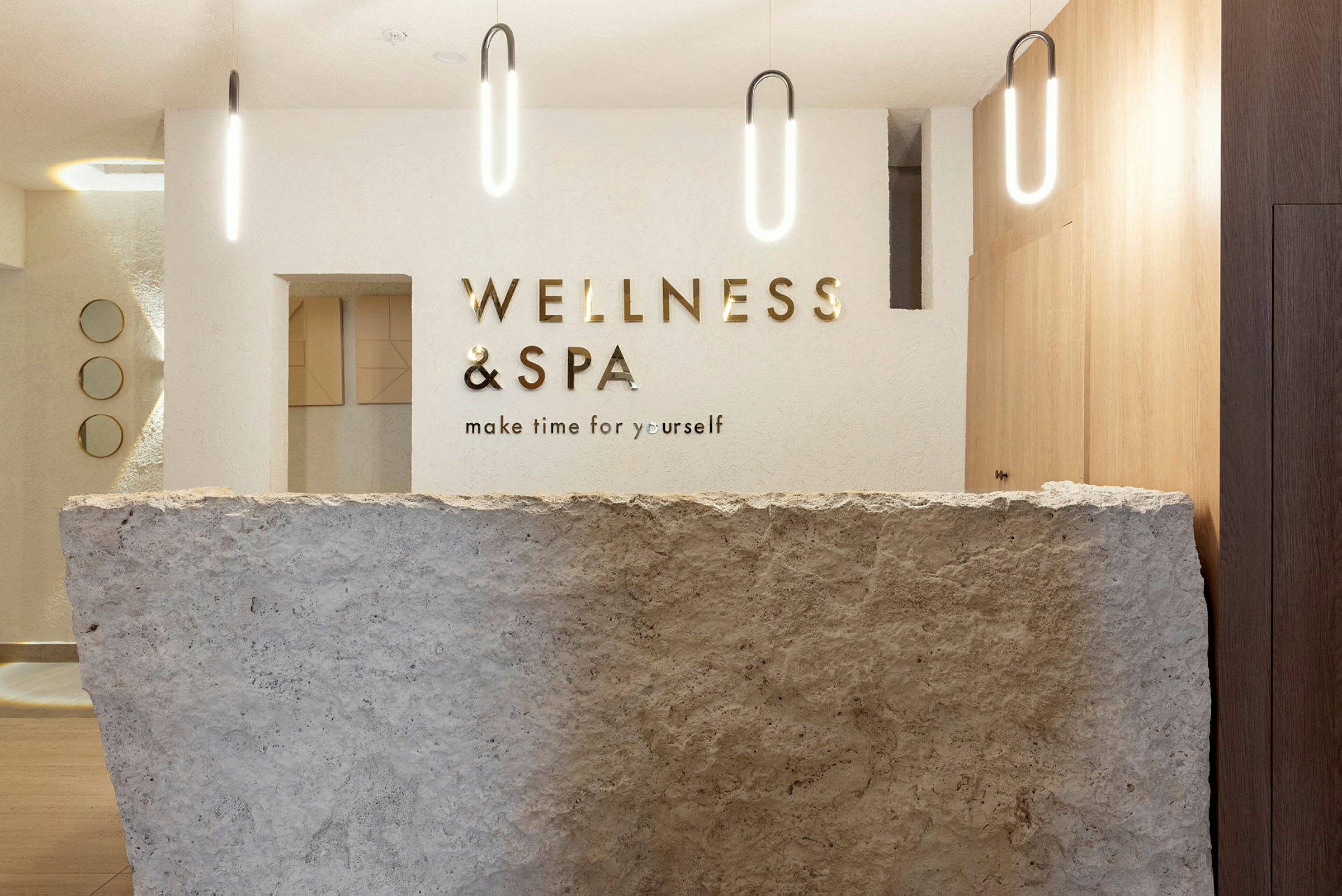 Receptionen på en spa- och wellnessanläggning, med en stenfront och modern belysning. (AI-genererad text)