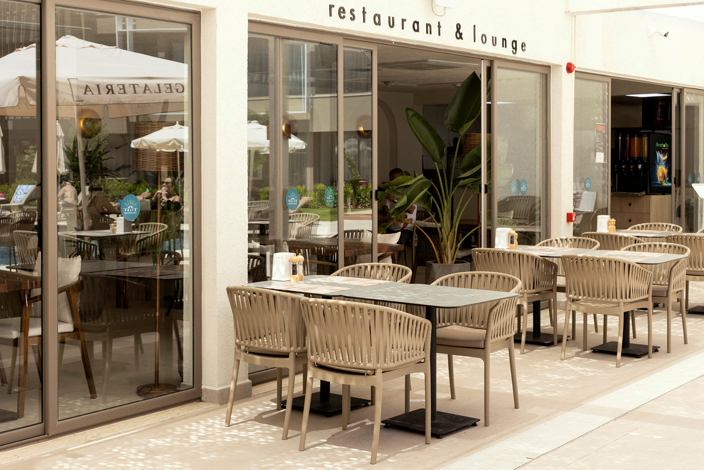 Utomhusdel av en restaurang med bord och stolar utplacerade på en terrass. (AI-genererad text)