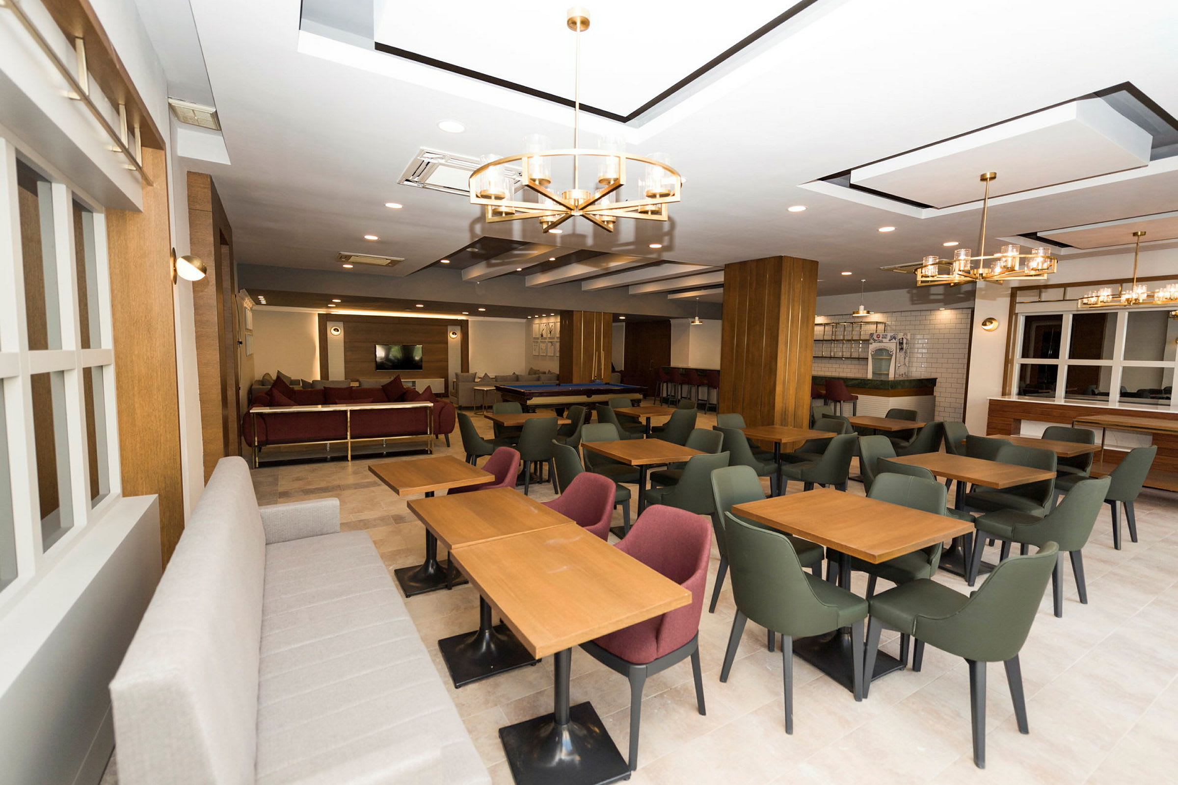 En modern restaurang med bord, stolar och soffor. (AI-genererad text)