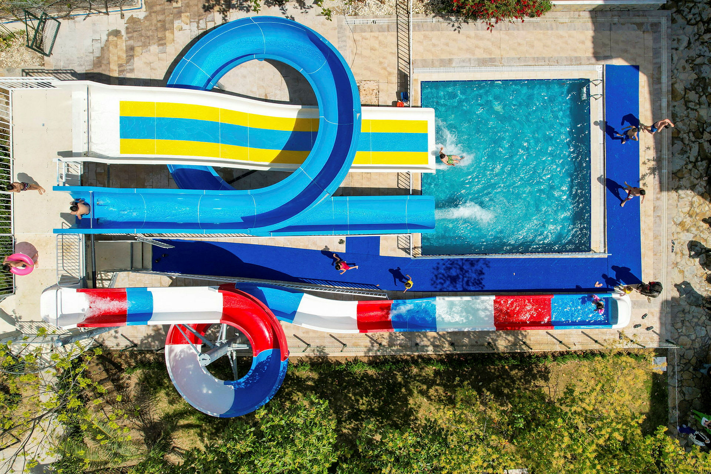 Bild av en vattenpark med flera vattenrutschbanor som leder till en pool. (AI-genererad text)