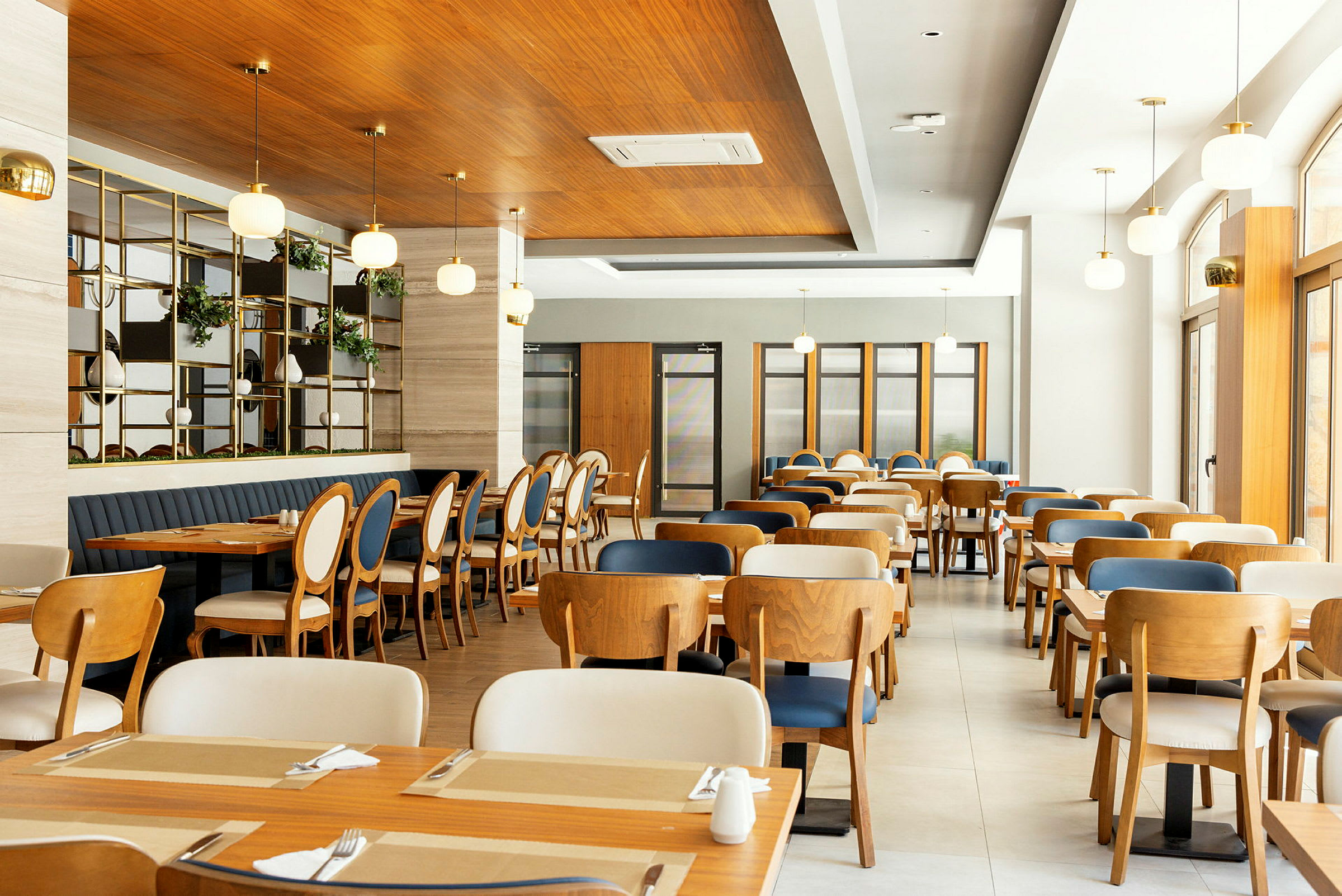 Interiör av en modern restaurang med träbord och stolar. (AI-genererad text)