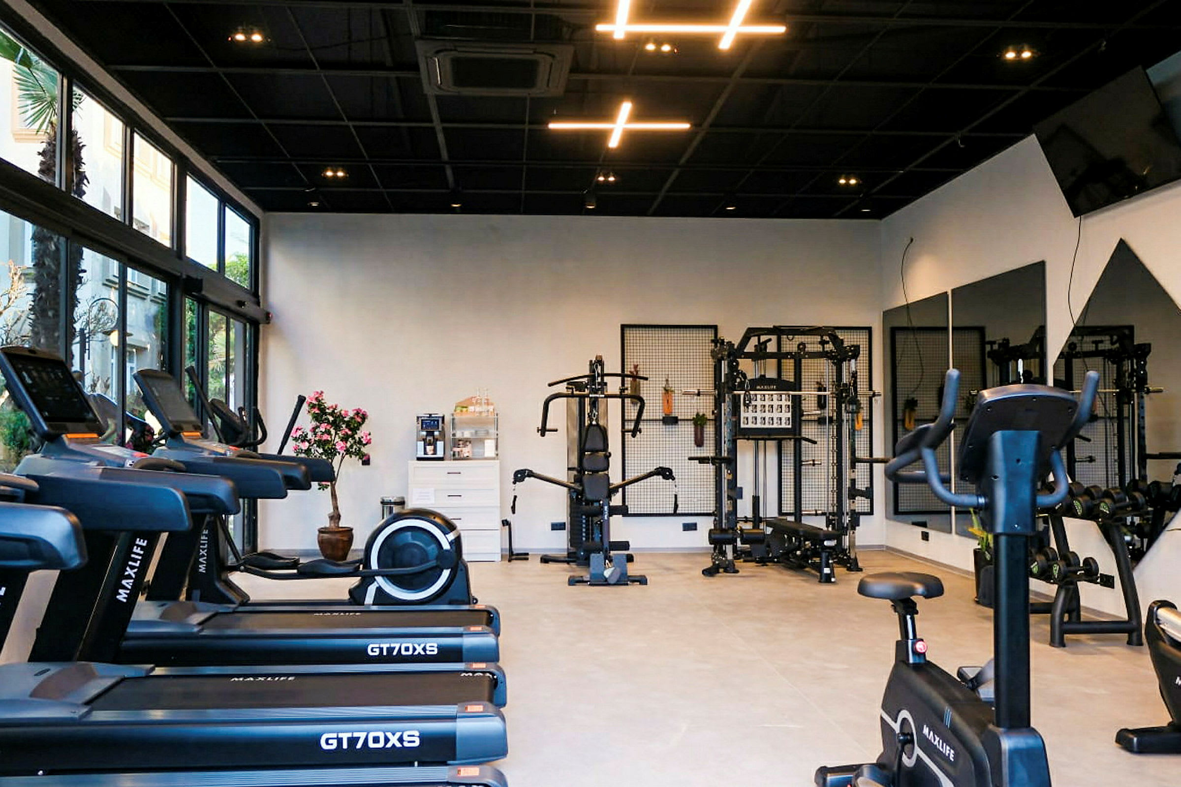 Moderna gymmaskiner och träningsutrustning i ett ljus och väl belyst rum. (AI-genererad text)