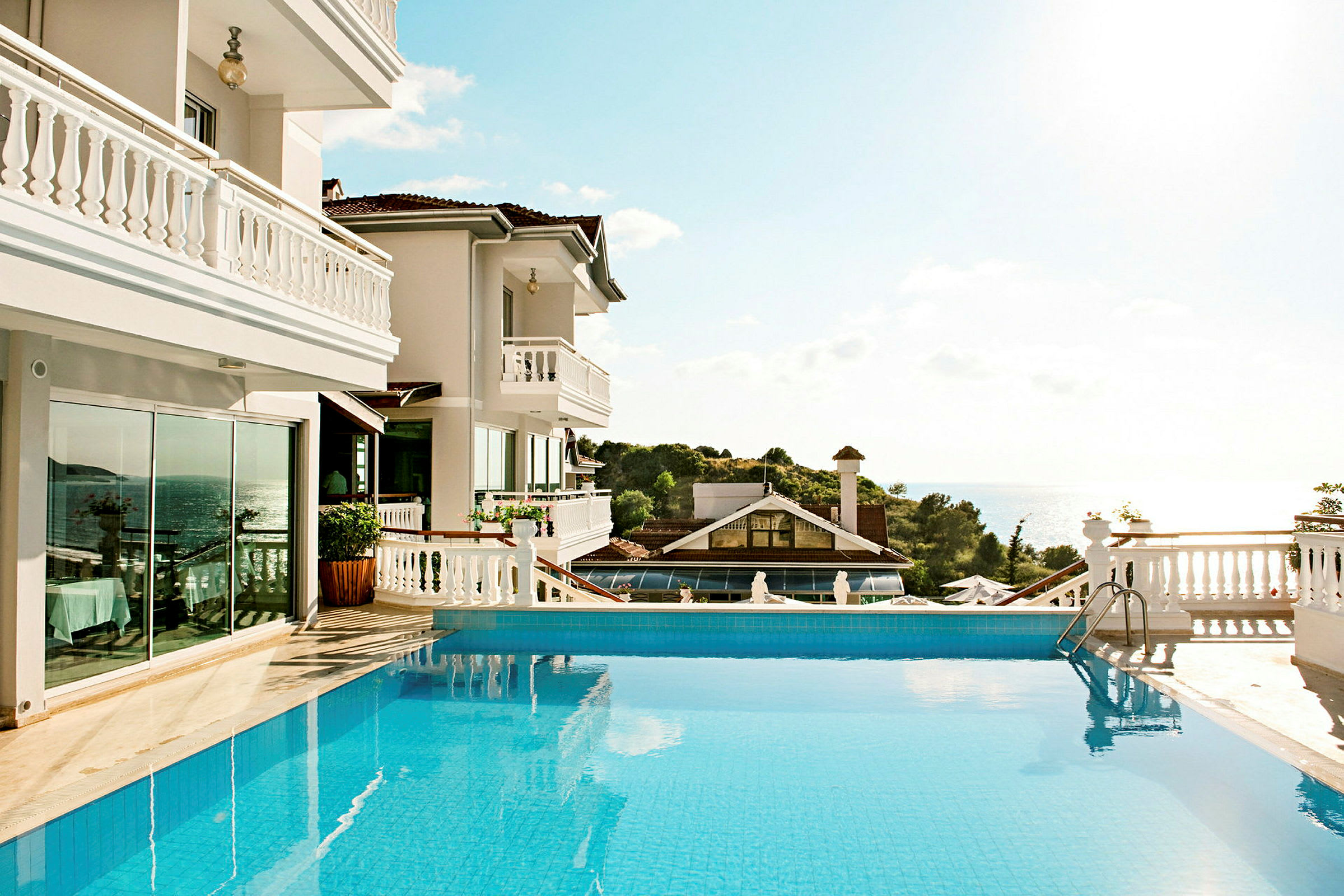 Hotell med en solbelyst pool och utsikt över havet. (AI-genererad text)