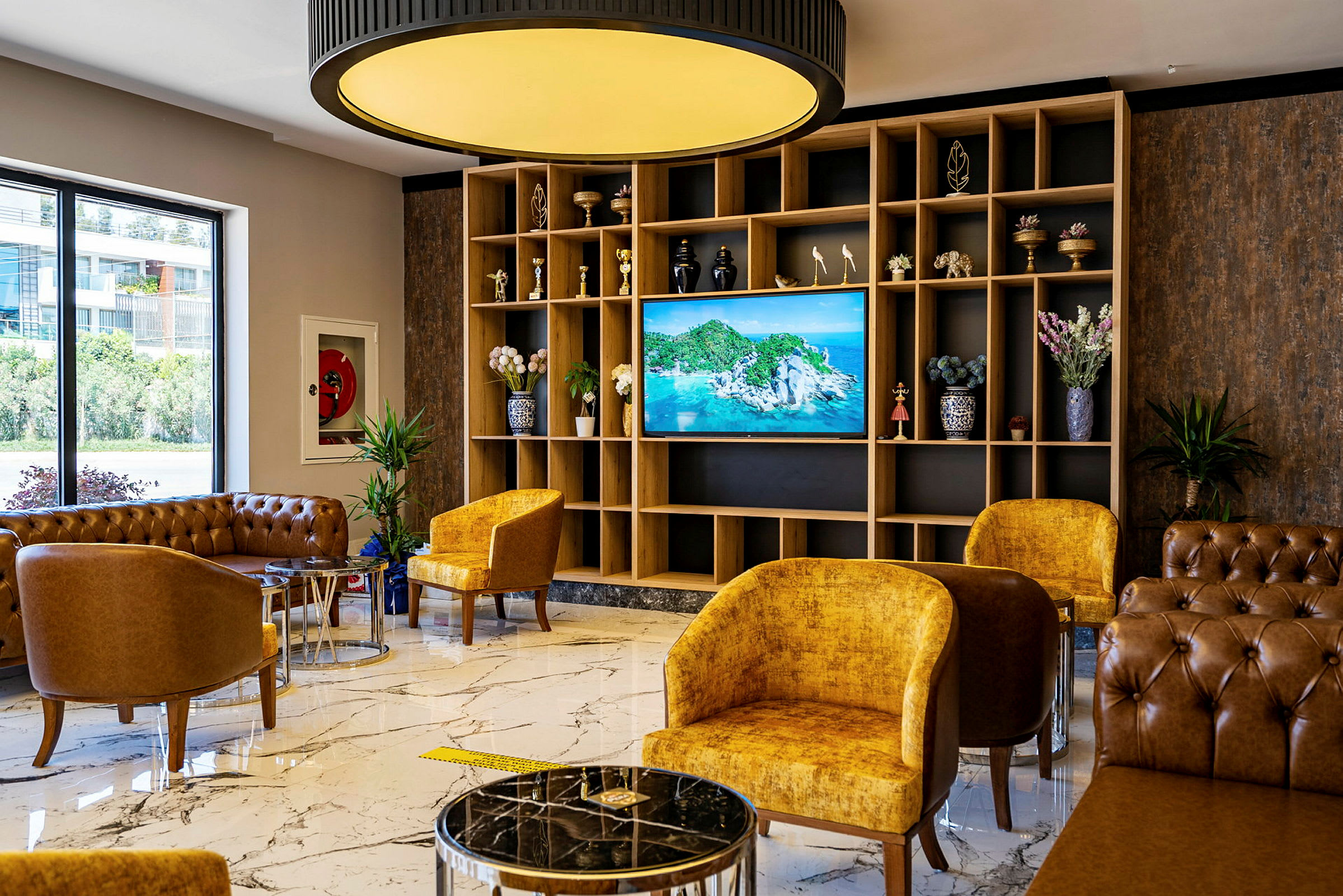 Hotellobby med sittmöbler, marmorgolv och en TV med naturvy. (AI-genererad text)