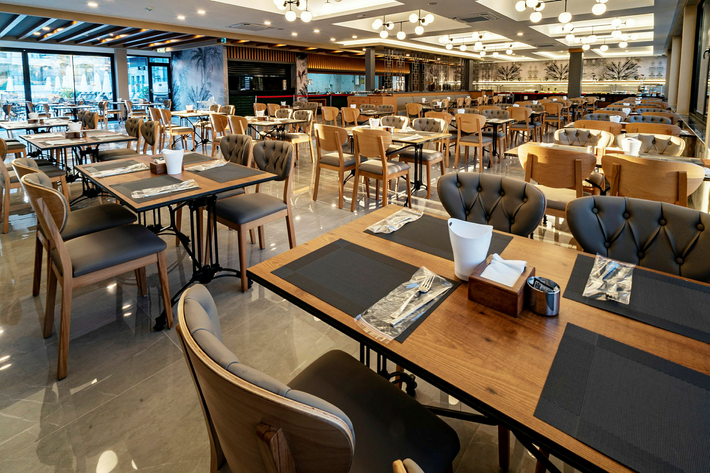 Bild av en restaurang med många bord och stolar, eleganta bordsdekorationer och modern belysning. (AI-genererad text)