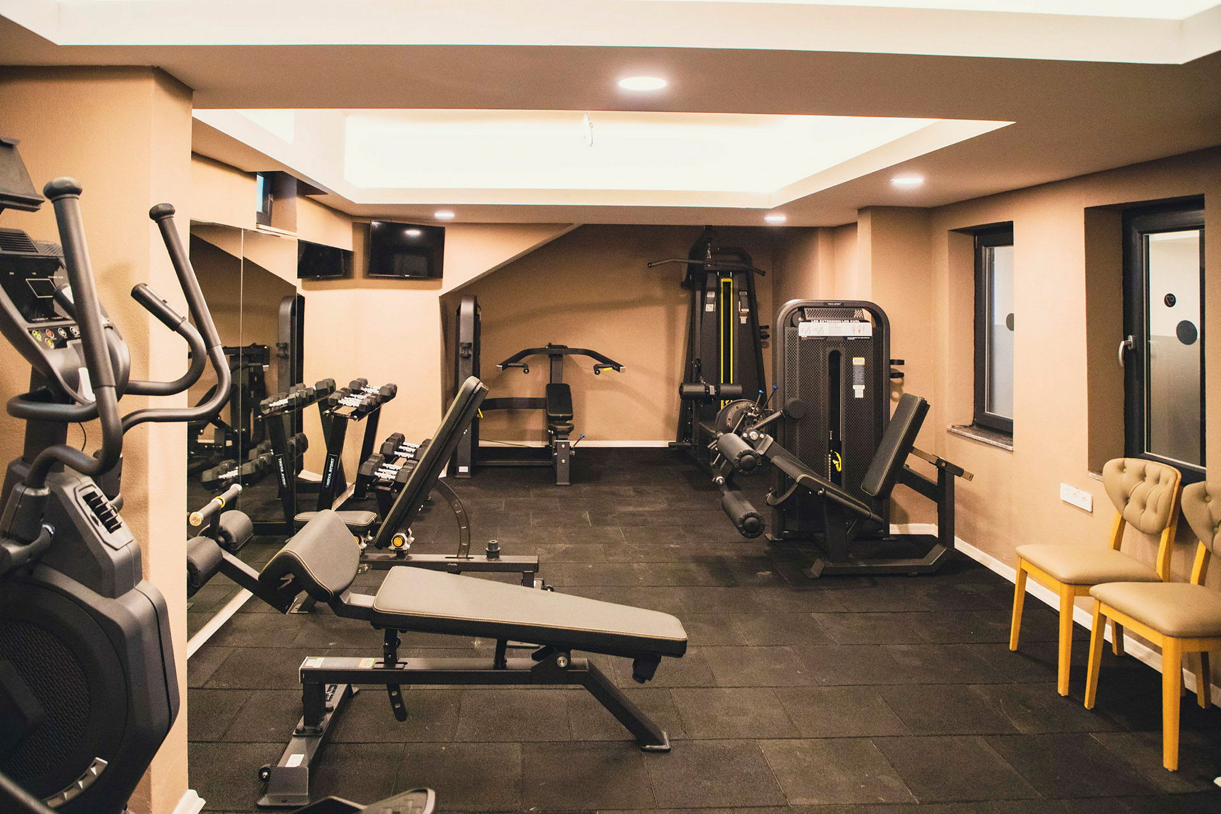 Ett gym med träningsmaskiner, bänkar och hantlar. (AI-genererad text)