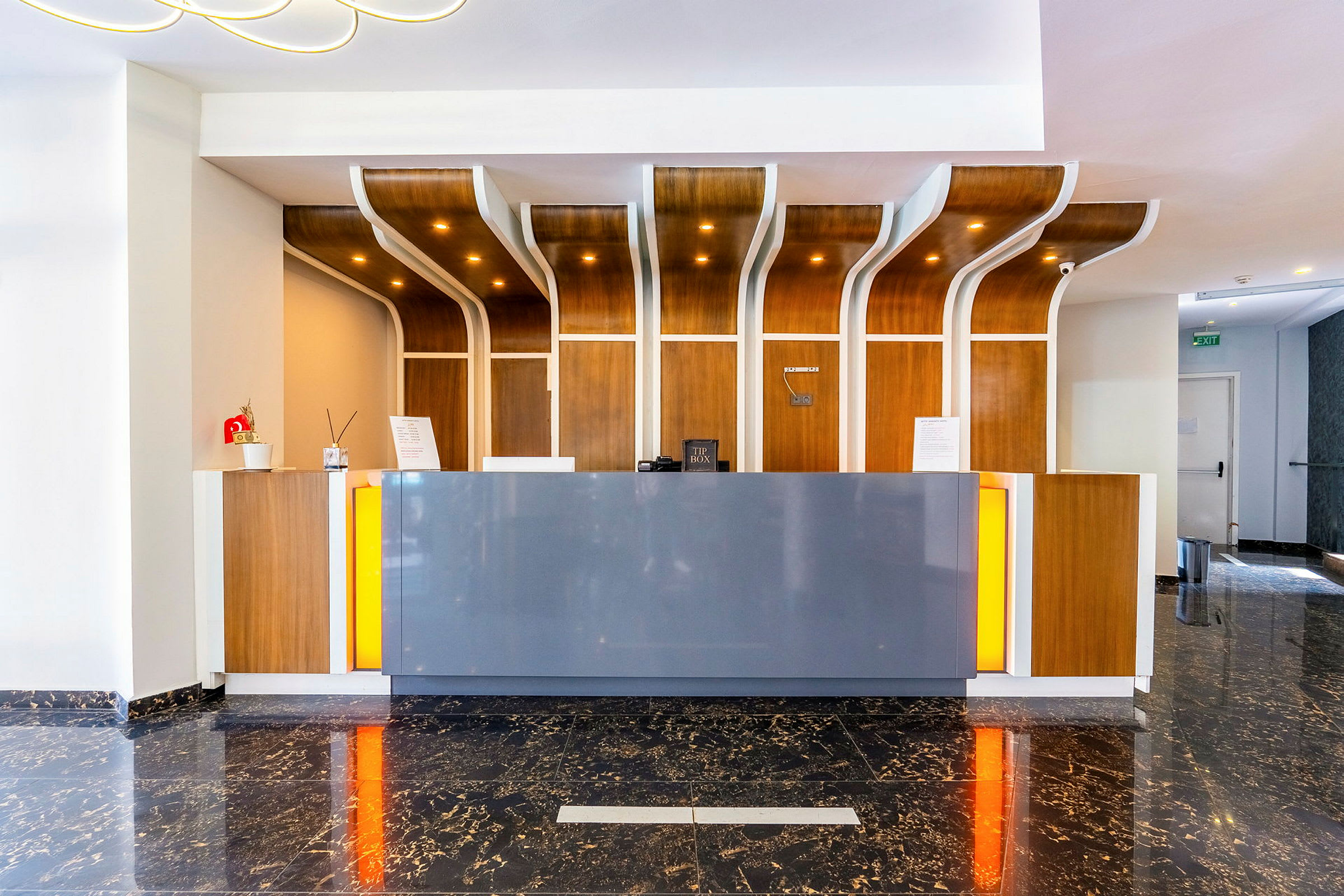 Hotellreception med modern design, trädetaljer och marmorgolv. (AI-genererad text)