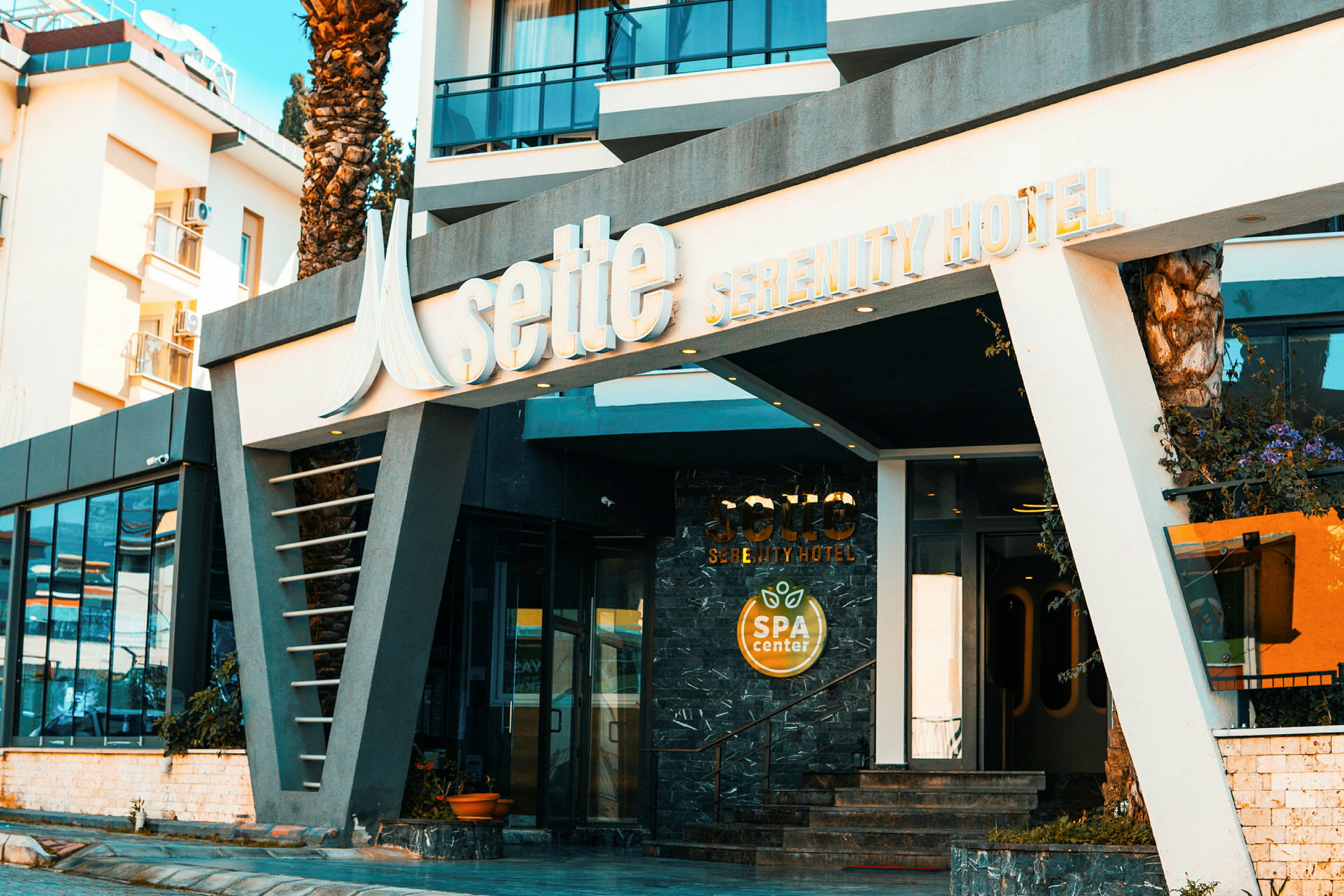 Ingången till Sette Serenity Hotel med en skylt för spa-center. (AI-genererad text)