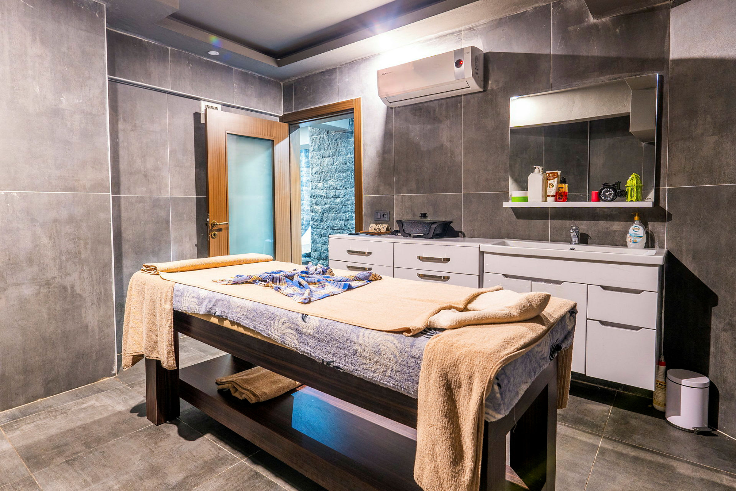 Ett spa-rum med massagebänk, handdukar och skåp. (AI-genererad text)
