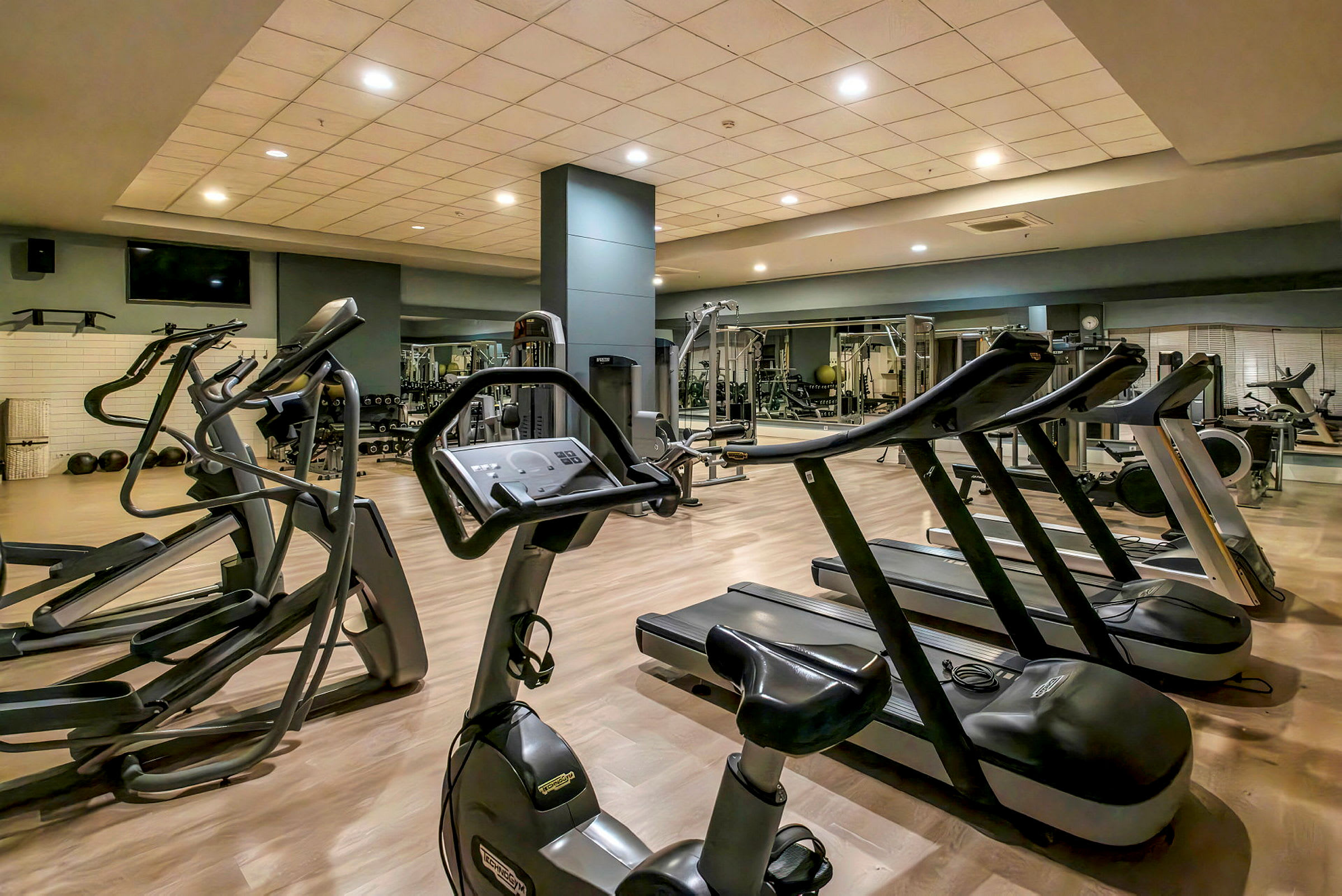 Ett gym med löpband, träningscykel och andra träningsmaskiner. (AI-genererad text)