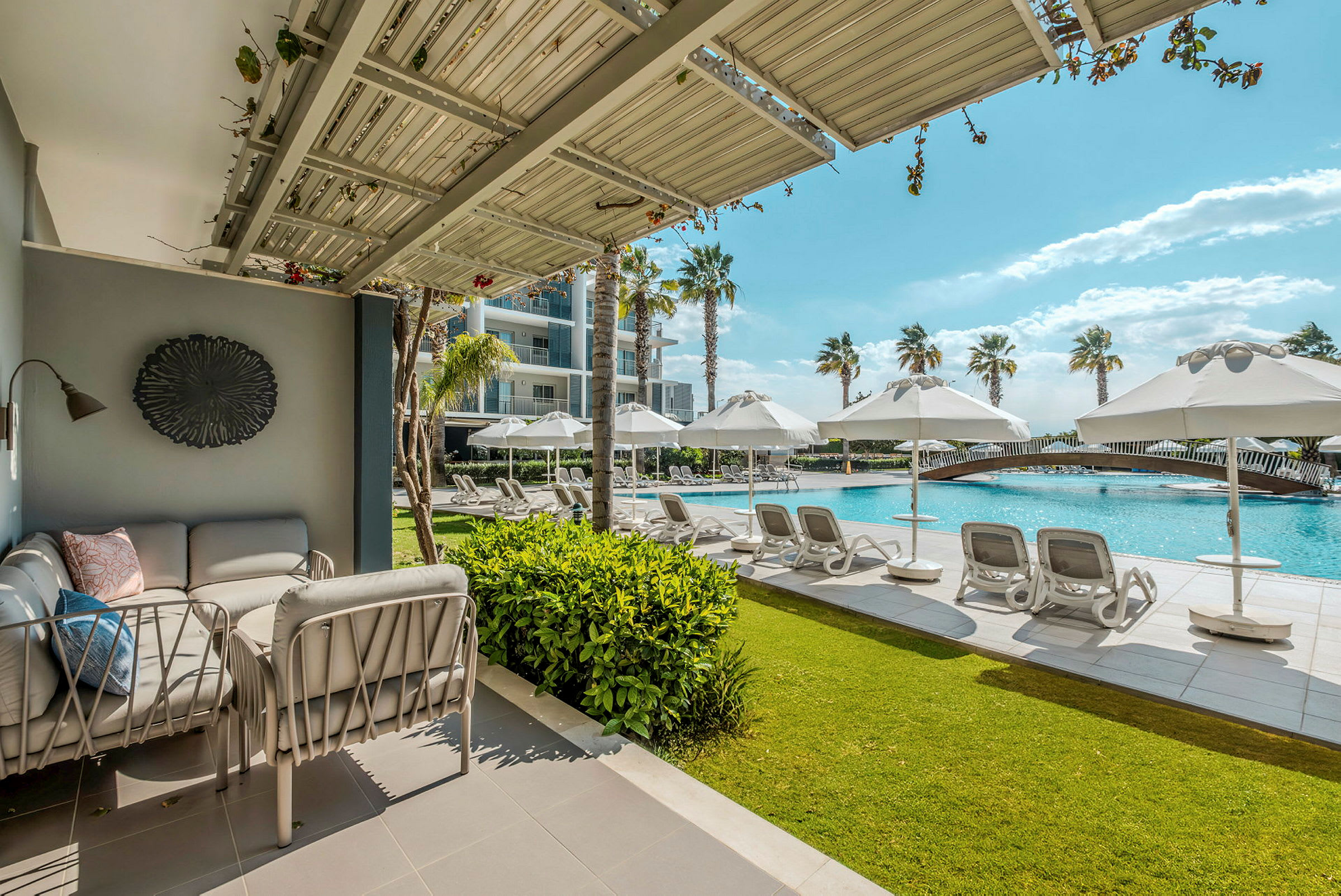 Loungeområde bredvid en pool med solstolar och parasoller. (AI-genererad text)