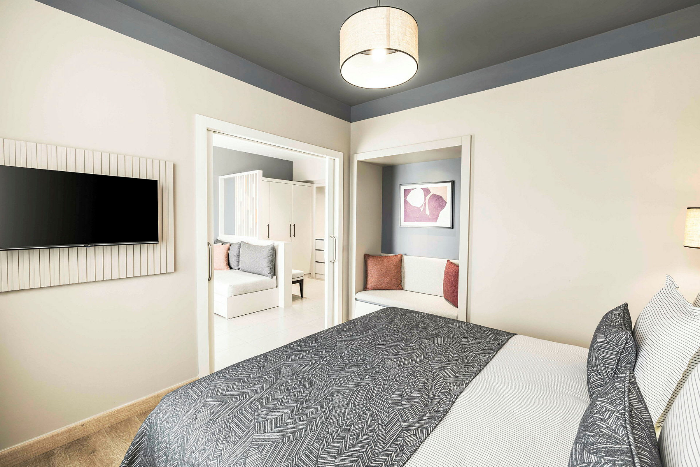 Modernt hotellrum med säng, textilier och sittdel. (AI-genererad text)