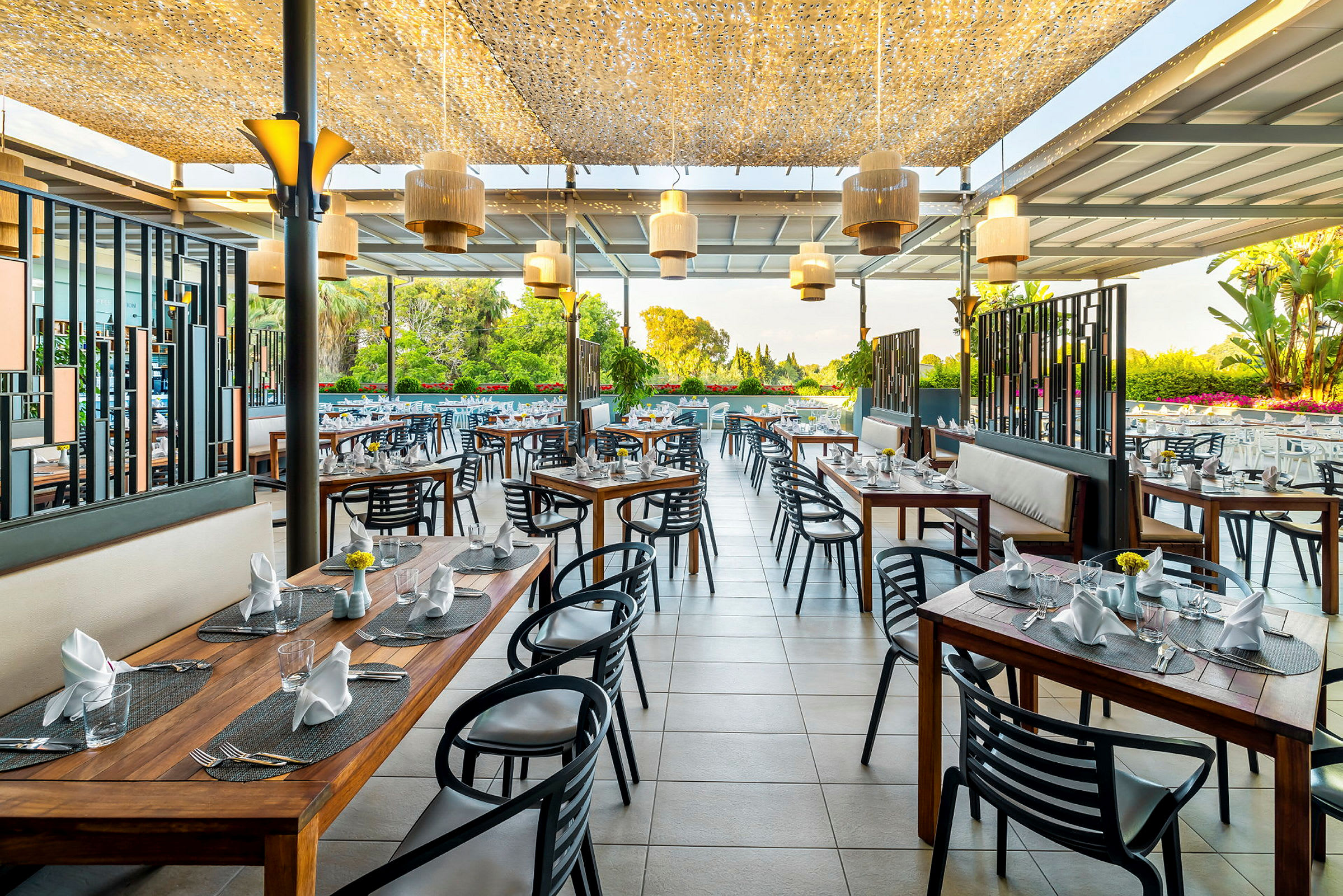 Restaurang med utomhusservering och moderna möbler, bord med dukning. (AI-genererad text)