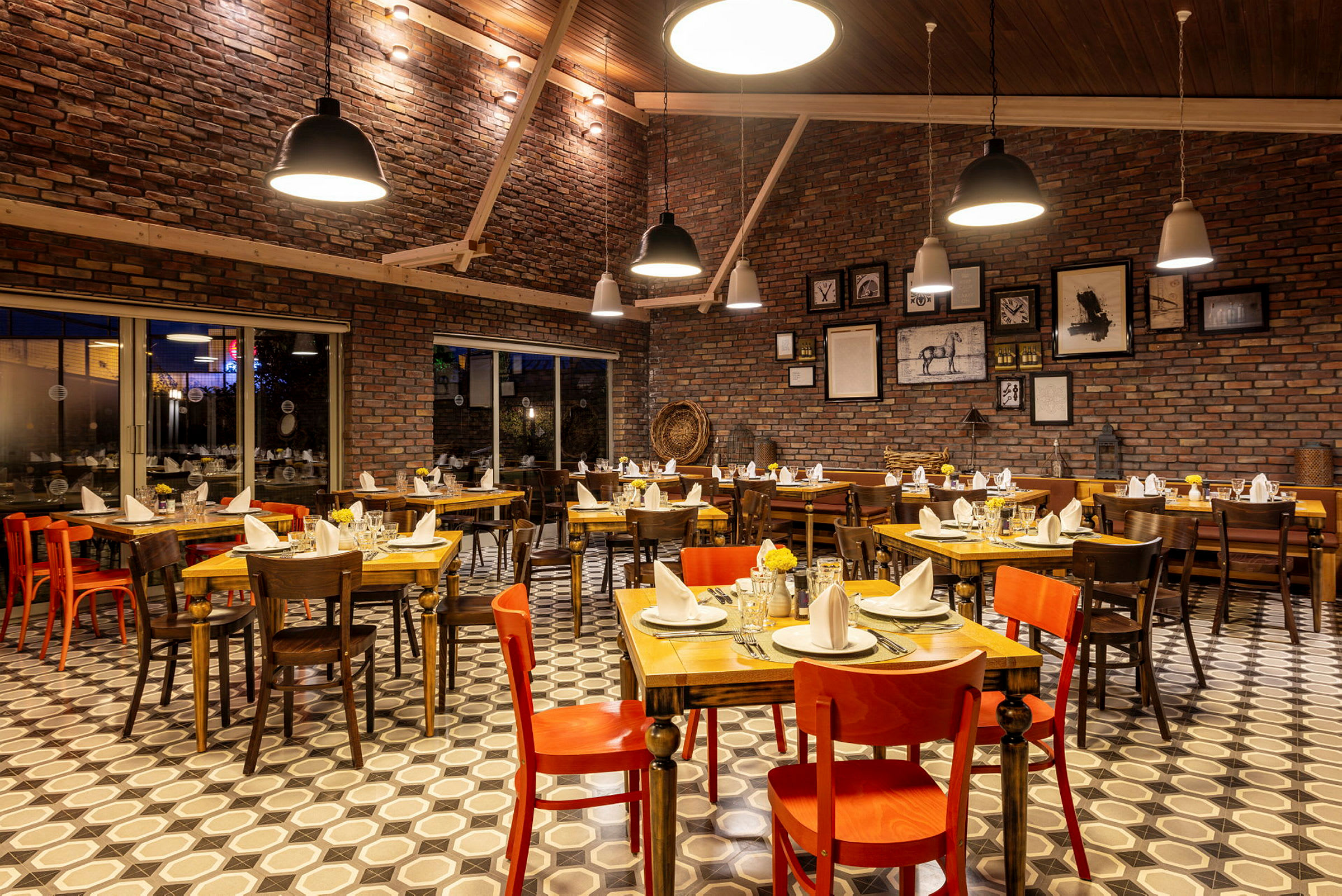 En restaurang med dukade bord, olika stolar och tegelväggar. (AI-genererad text)
