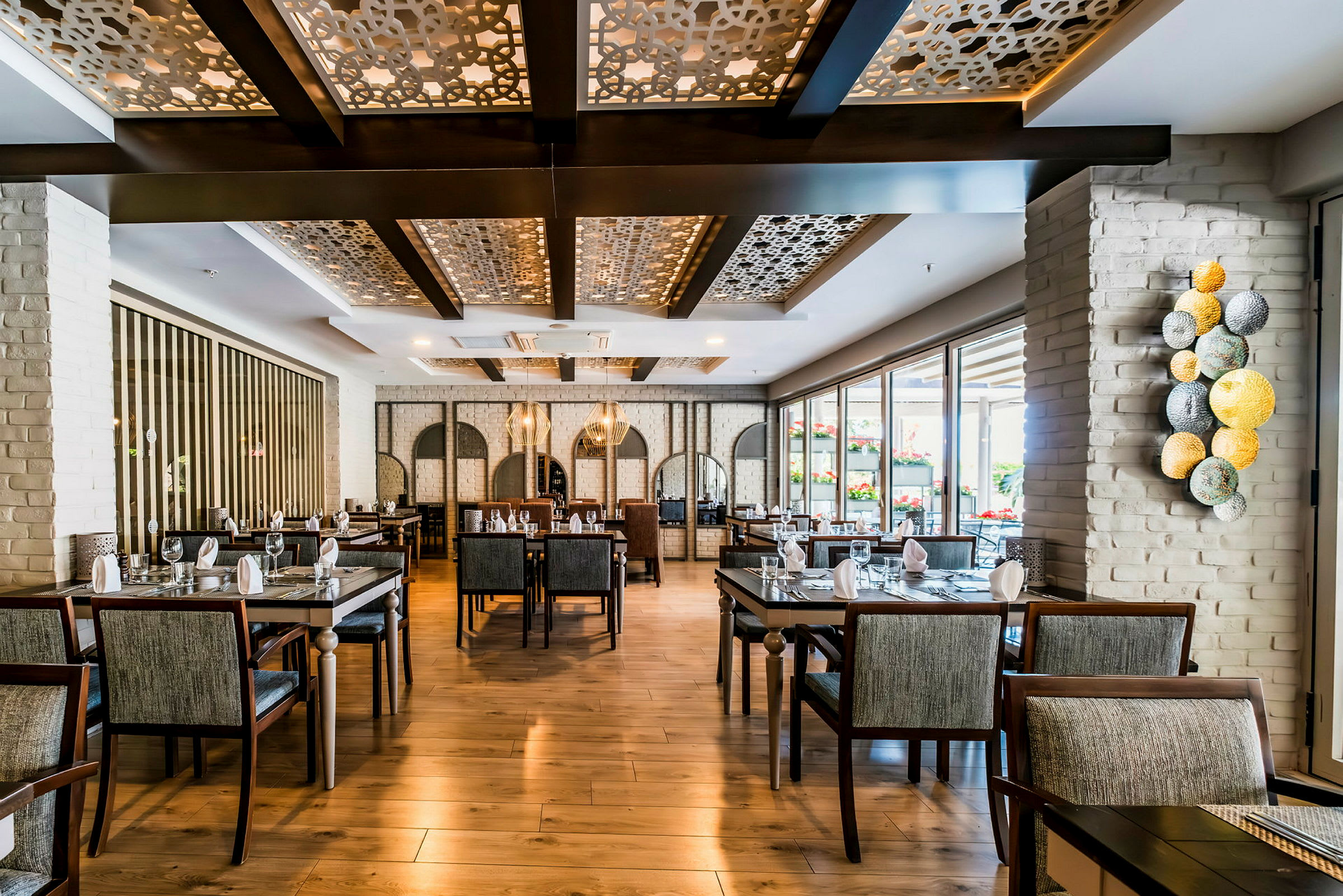 Interiör av en elegant restaurang med moderna möbler och dekorativa takdetaljer. (AI-genererad text)